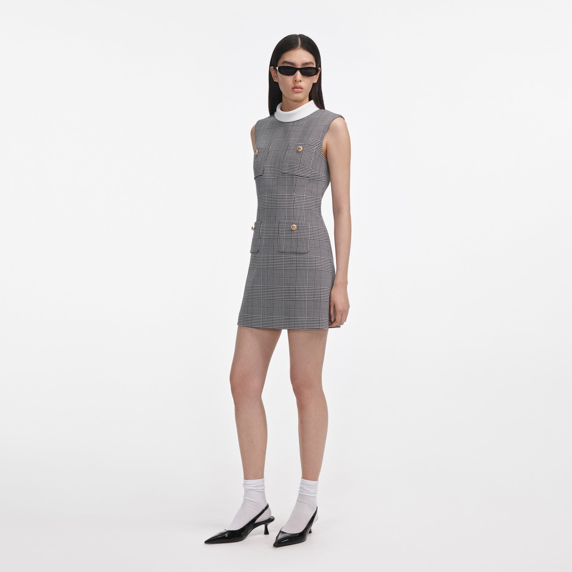 Side view of a woman wearing the Sleeveless Prince Of Wales Check Mini Dress
