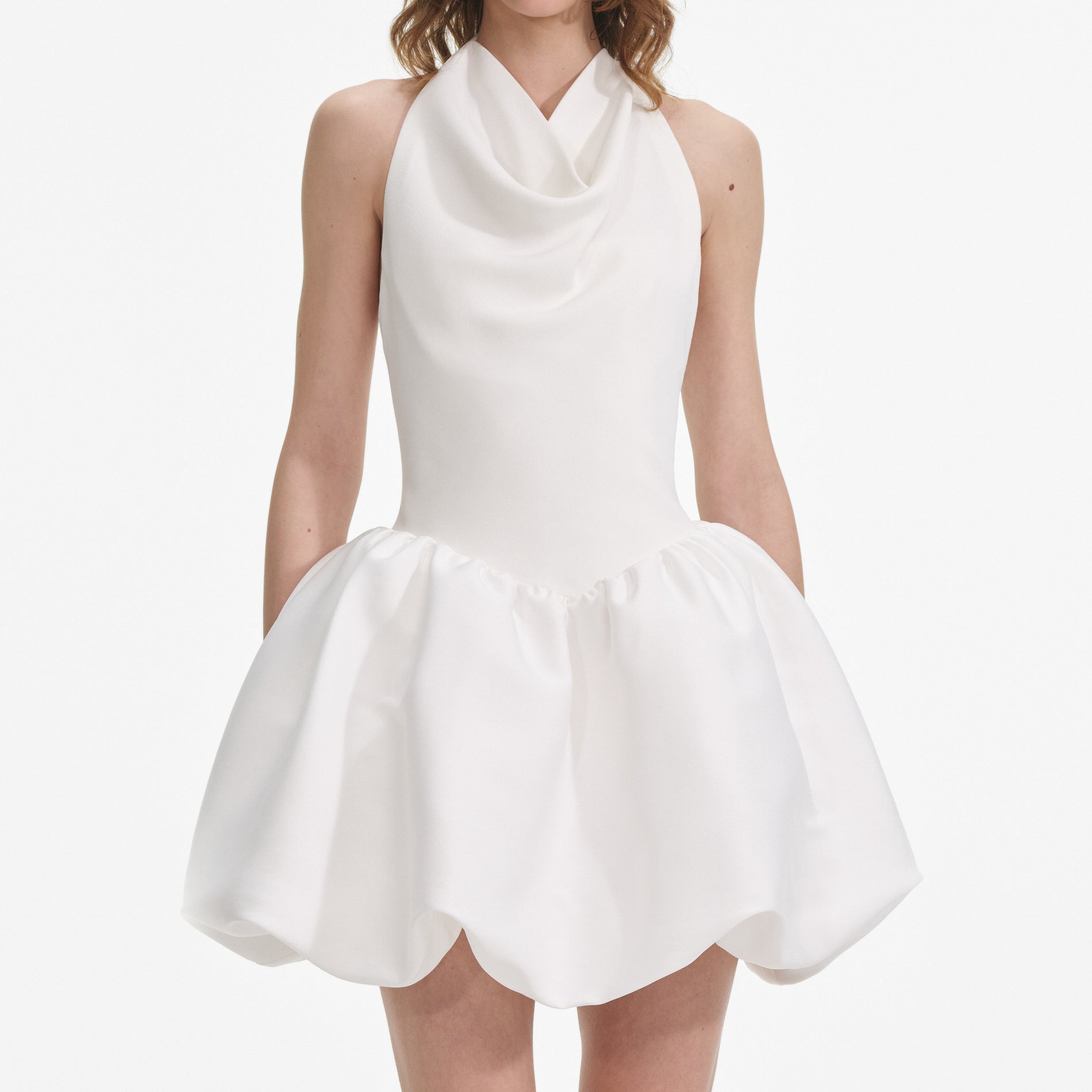 A close up of a woman wearing the White Halter Neck Mini Dress