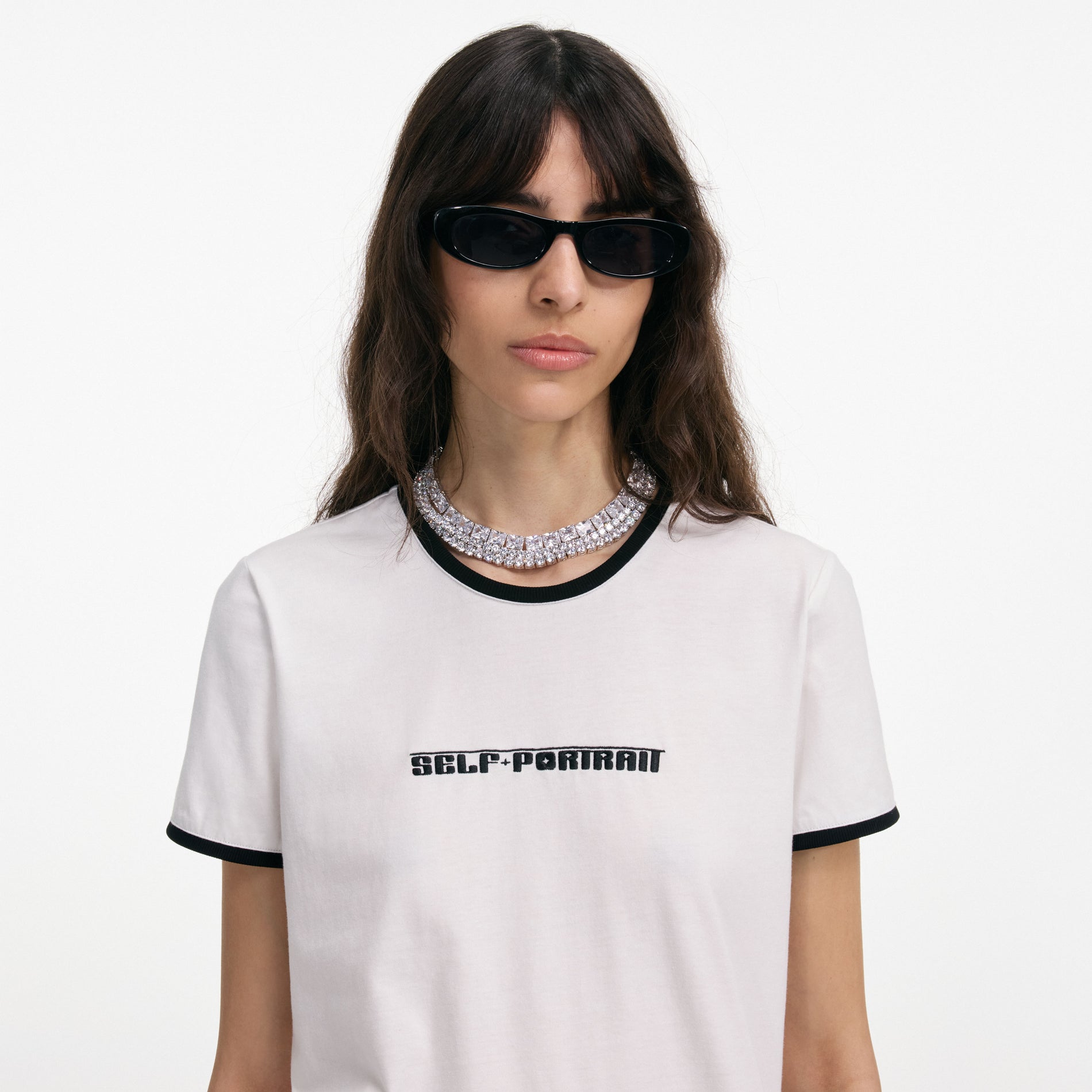A close up of a woman wearing the White T-Shirt With Embroidered Logo