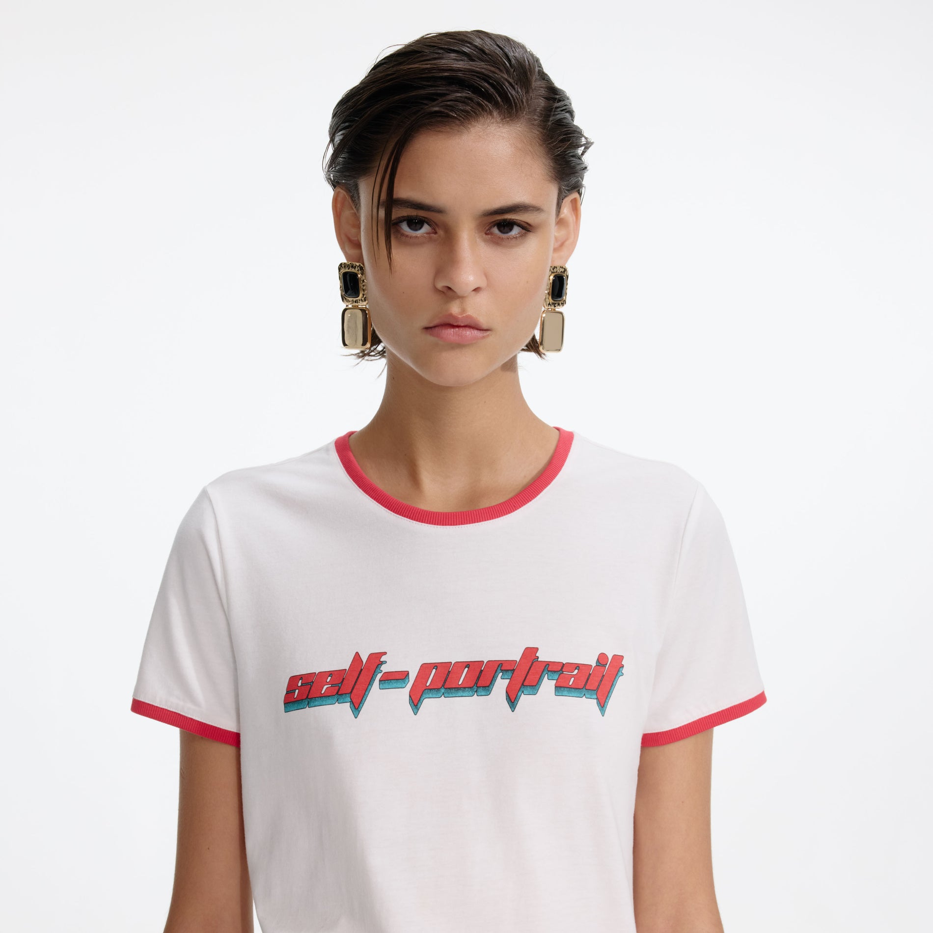A close up of a woman wearing the White T-Shirt With Red Logo