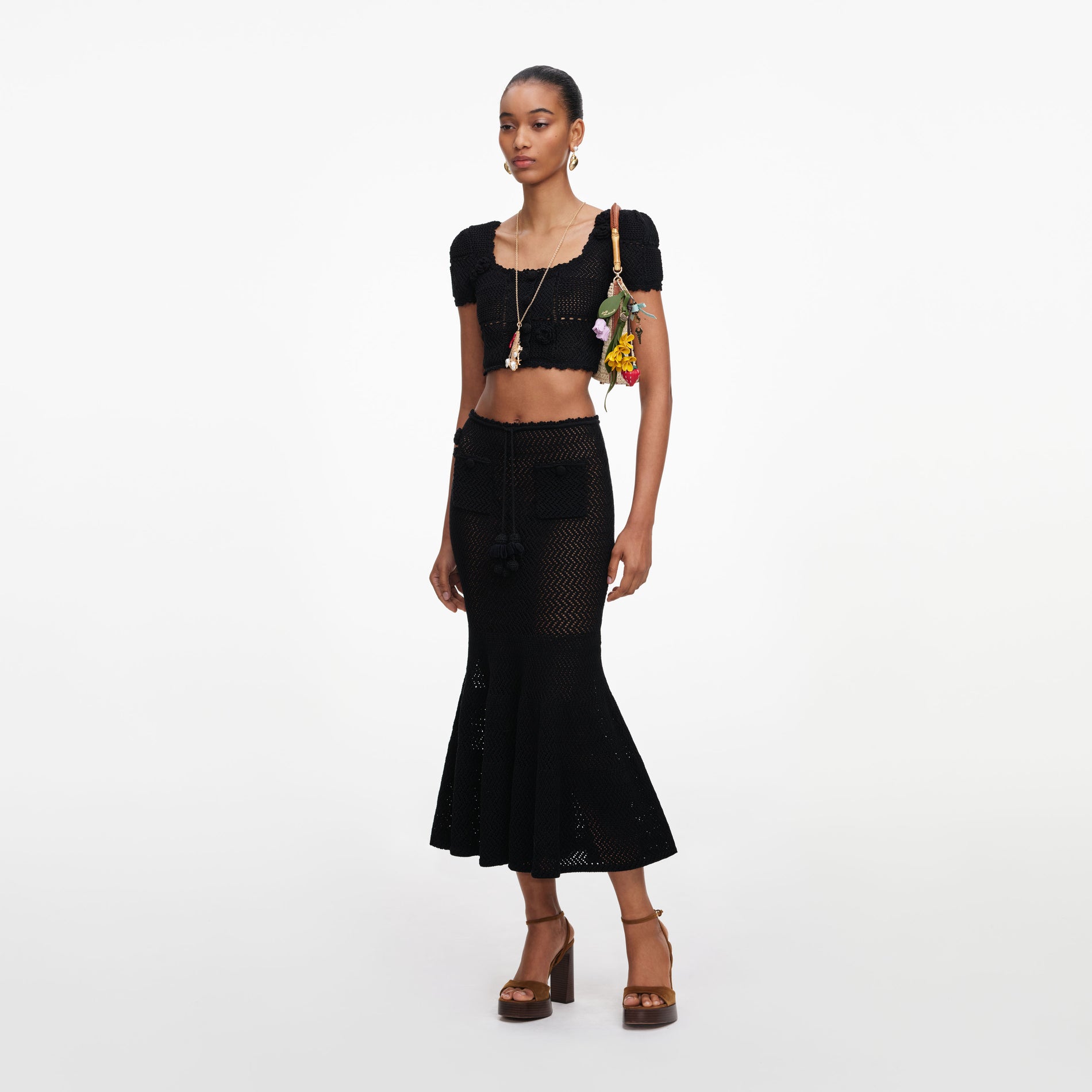 Side view of a woman wearing the Black Crochet Knit Midi Skirt