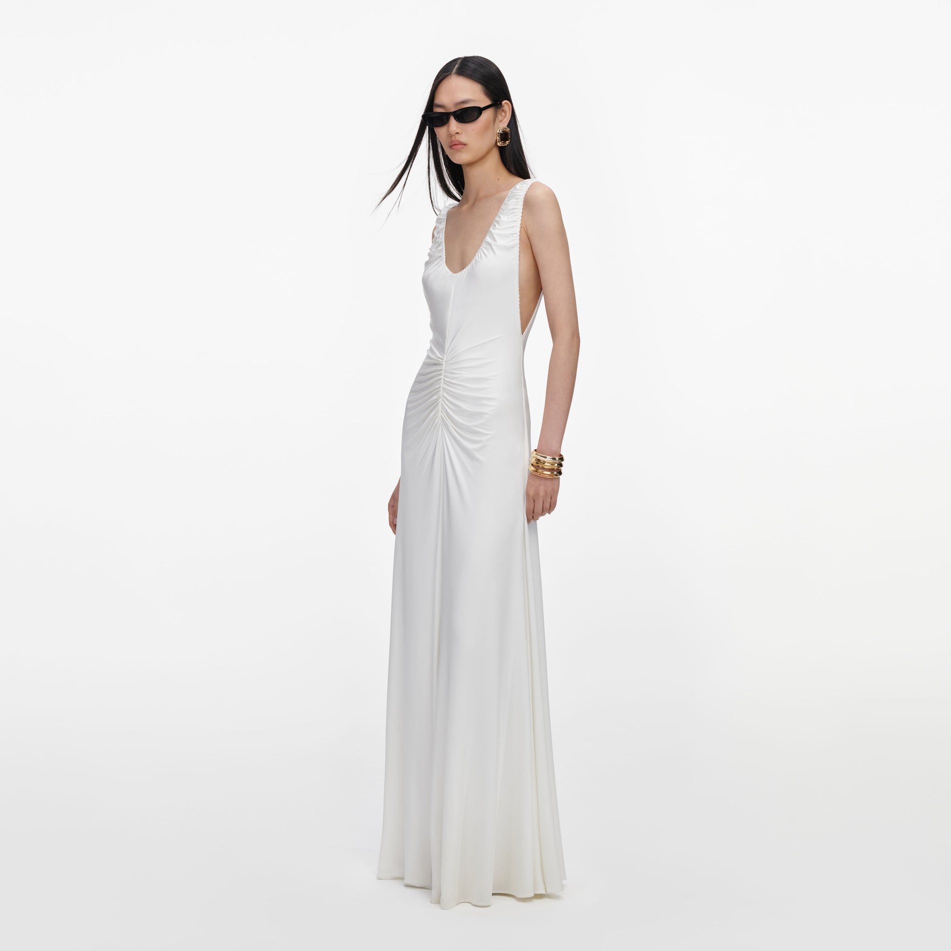 Side view of a woman wearing the White Jersey Ruched Maxi Dress