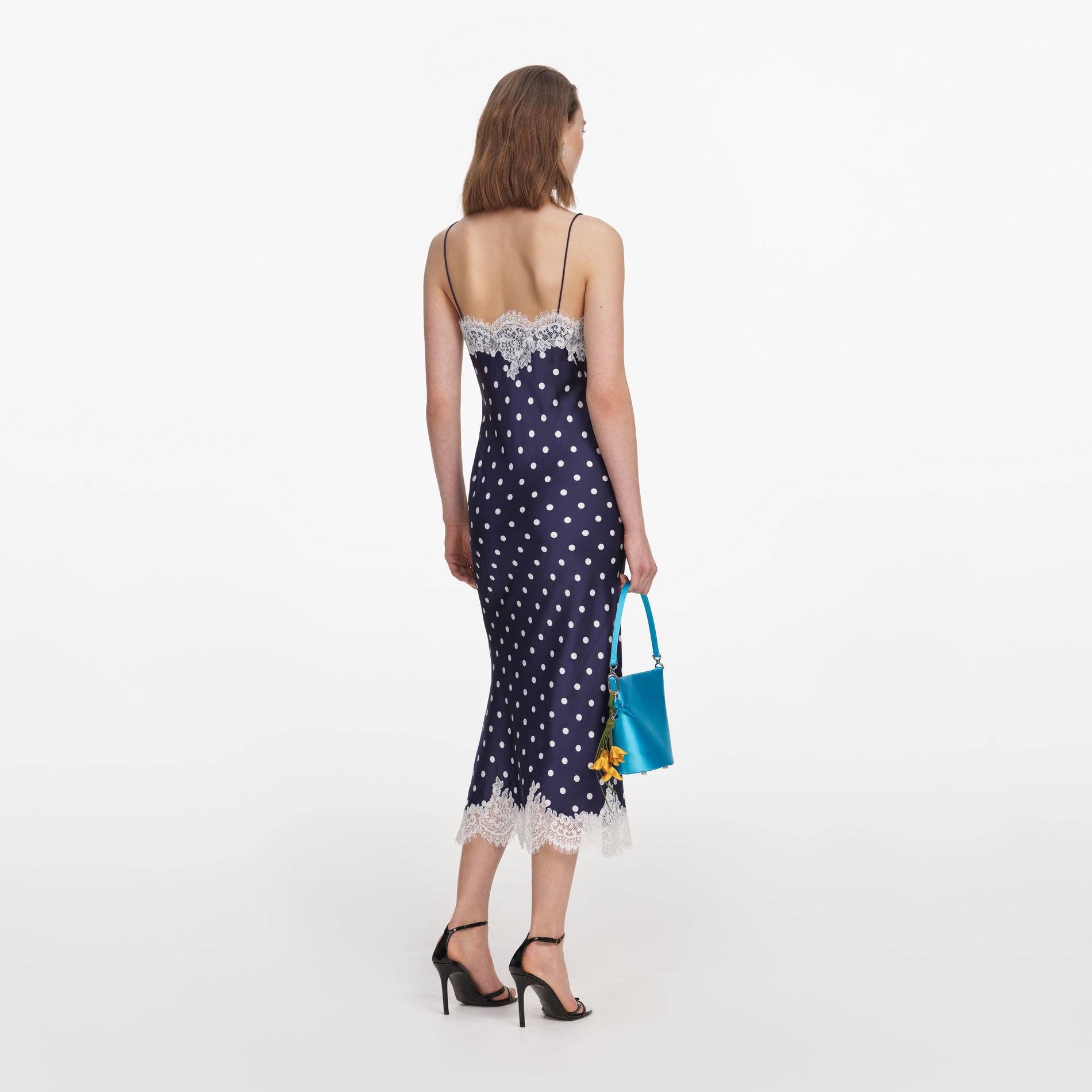 Back view of a woman wearing the Navy Polka Dot Satin Midi Dress