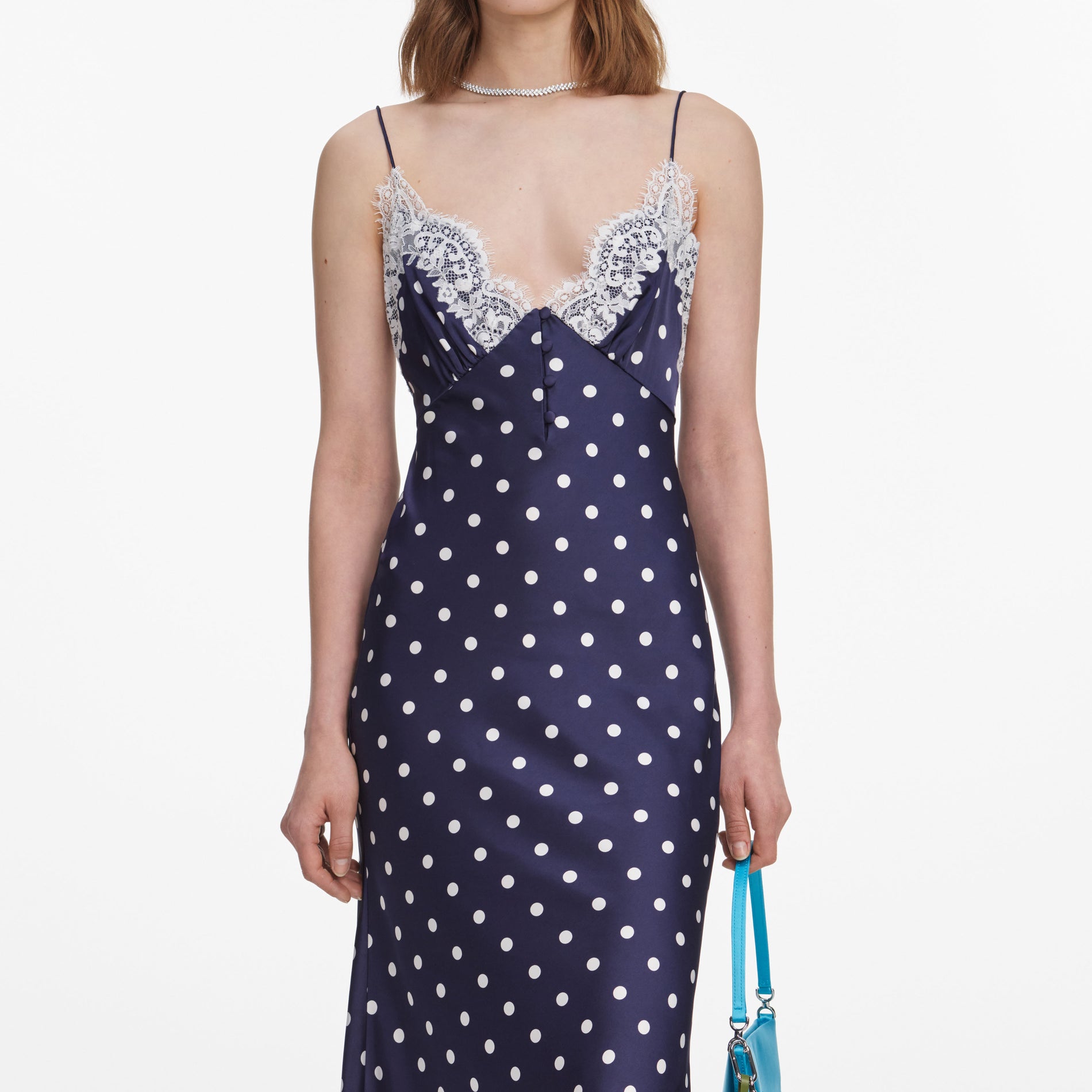 A close up of a woman wearing the Navy Polka Dot Satin Midi Dress
