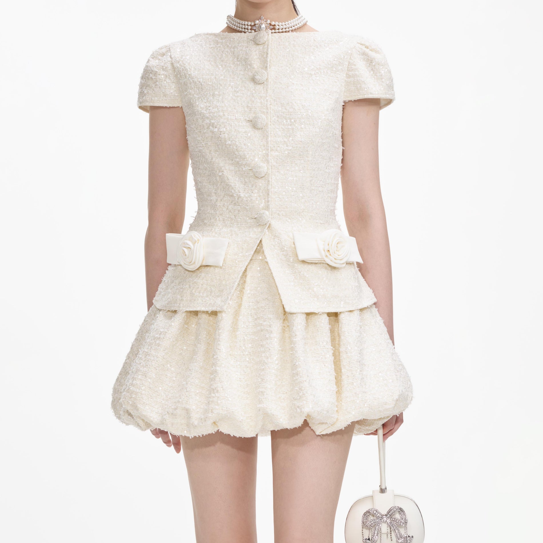 A close up of a woman wearing the Cream Boucle Bow Detail Mini Dress
