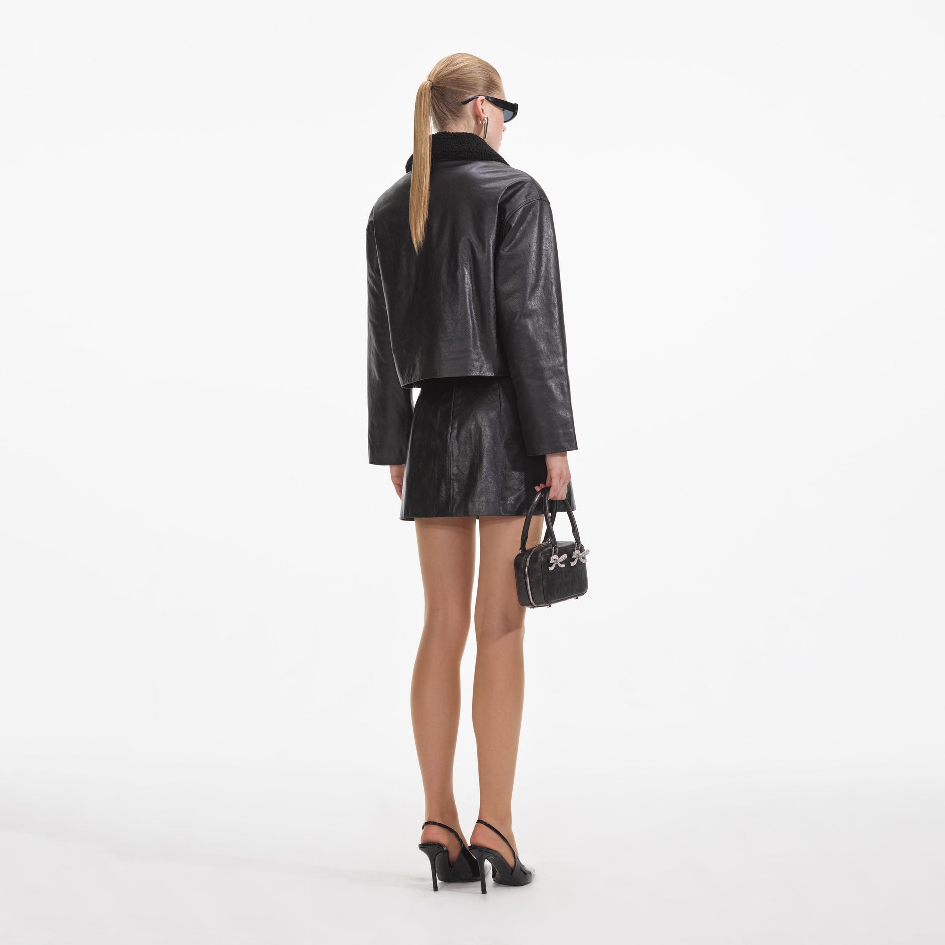 Back view of a woman wearing the Black Leather Shearling Jacket