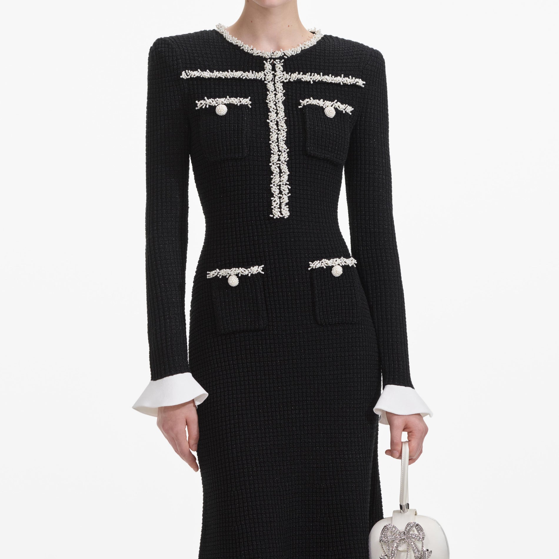 A close up of a woman wearing the Black Pearl Trim Knit Midi Dress