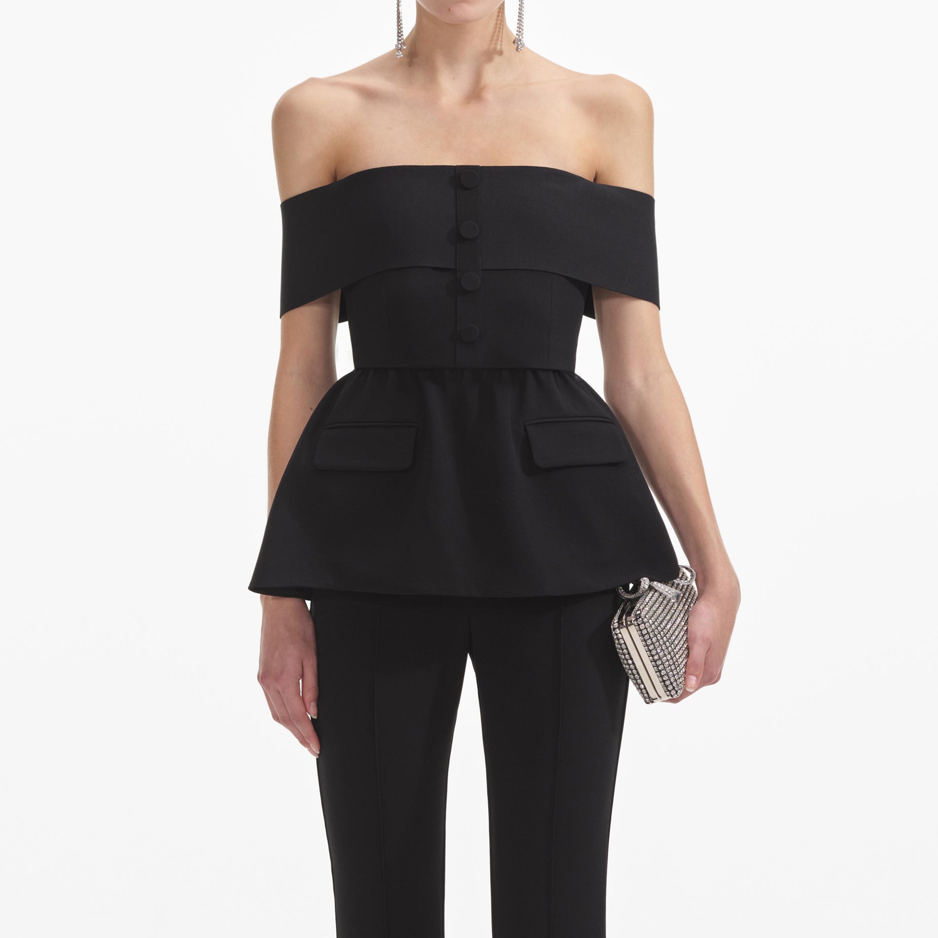 A close up of a woman wearing the Black Crepe Off Shoulder Jumpsuit