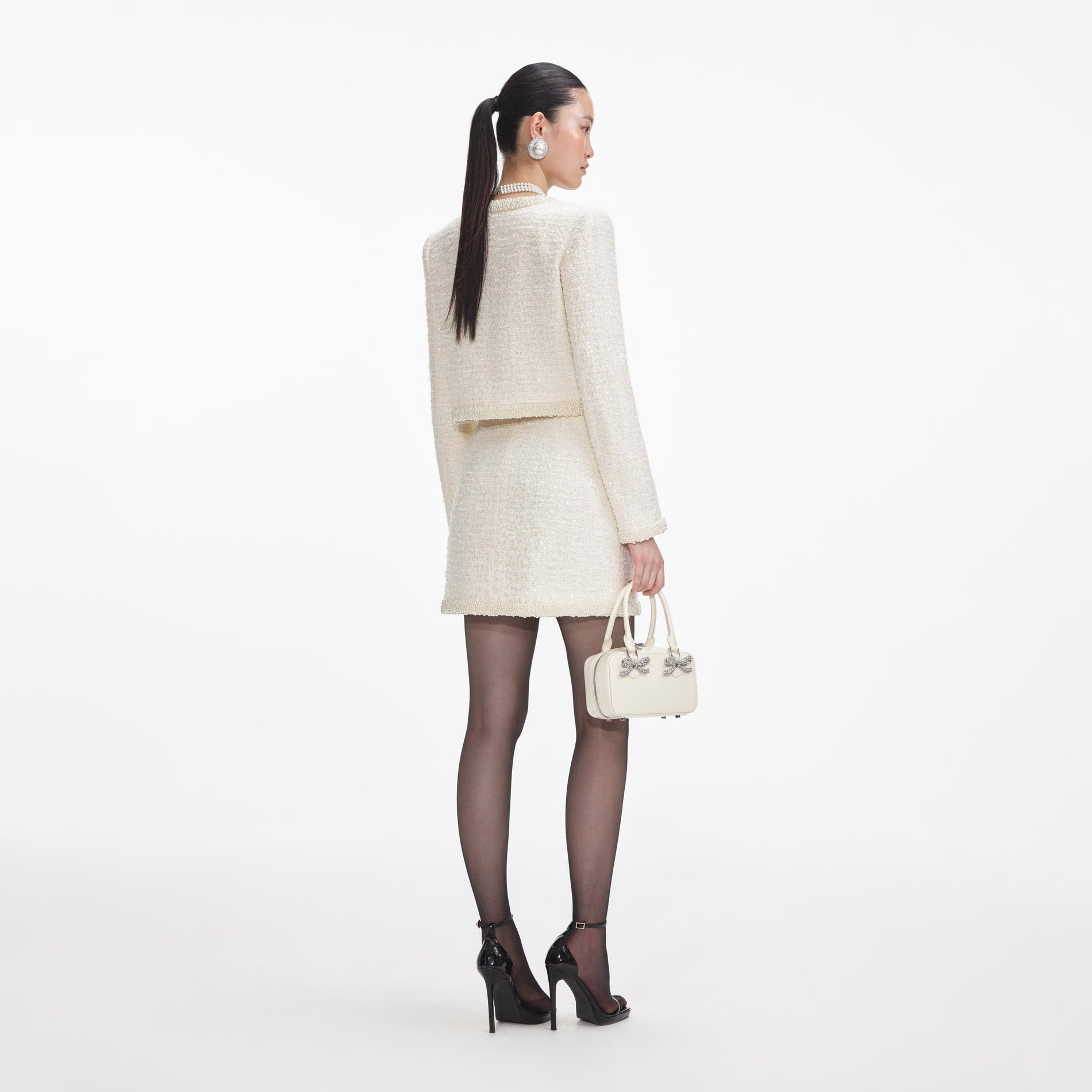 Back view of a woman wearing the Cream Boucle Pearl Trim Jacket