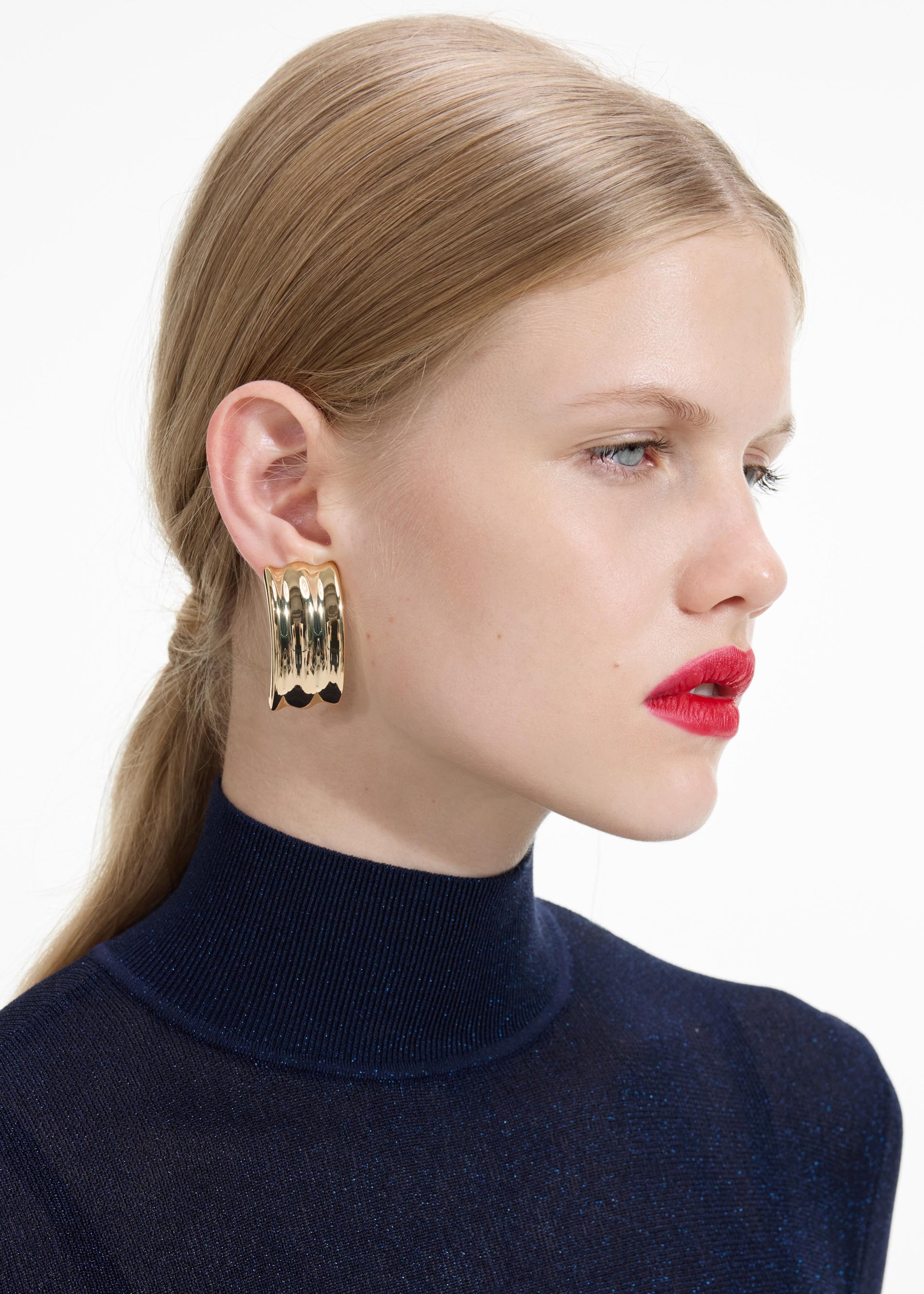 A close up of a woman wearing the Gold Ridged Earrings