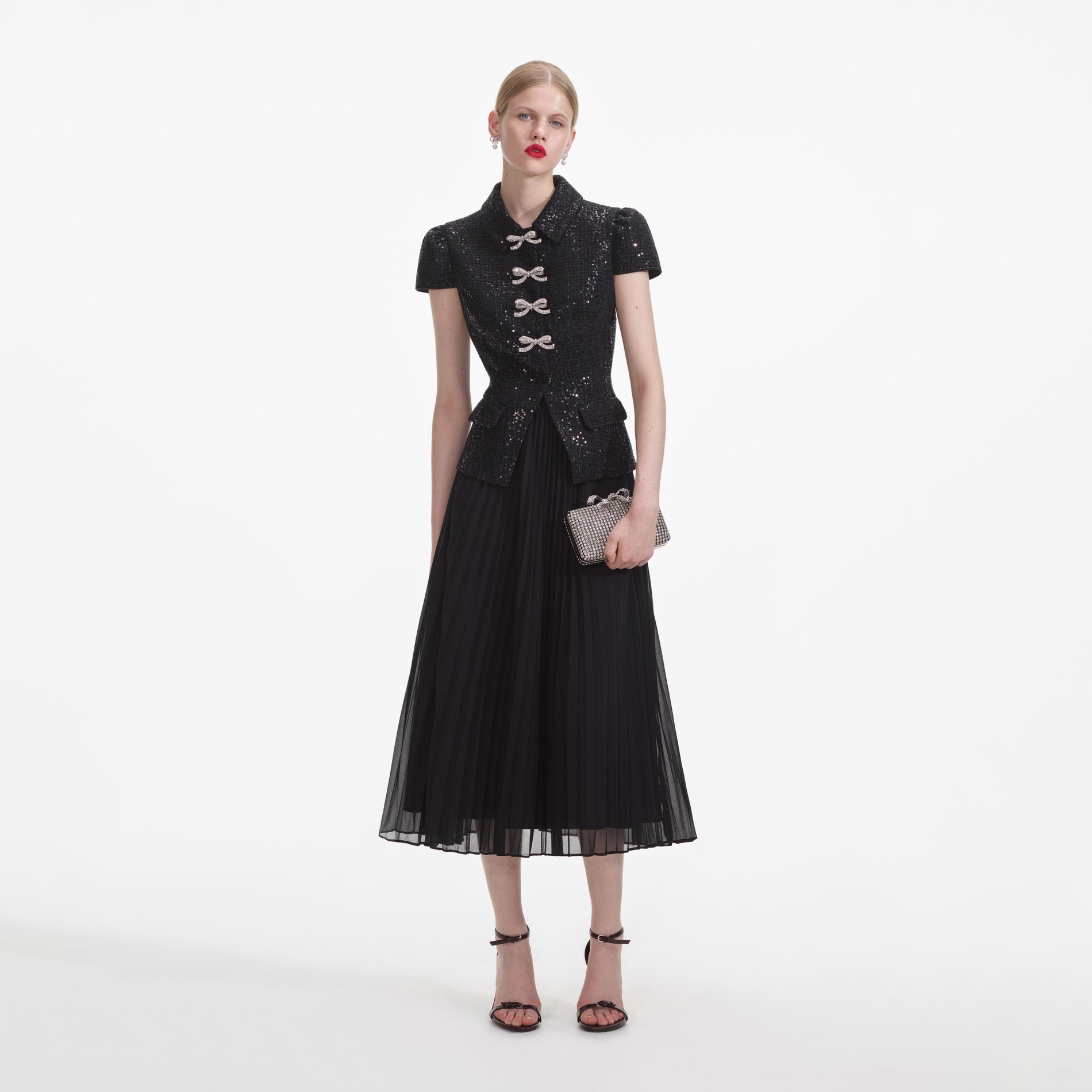A close up of a woman wearing the Black Boucle Bow Midi Dress