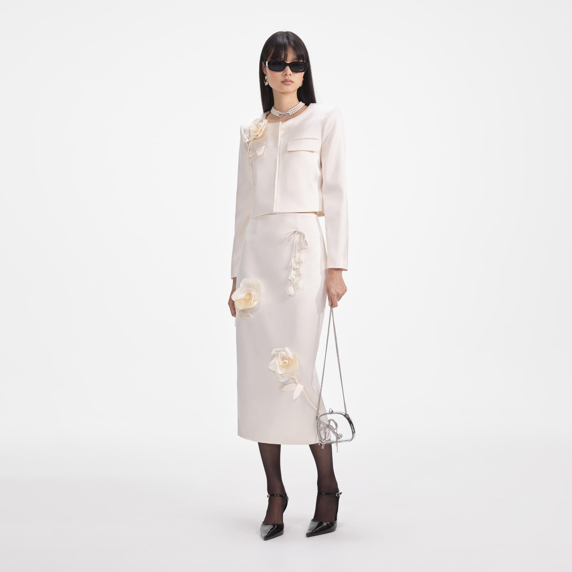 Side view of a woman wearing the Cream 3D Flower Satin Midi Skirt