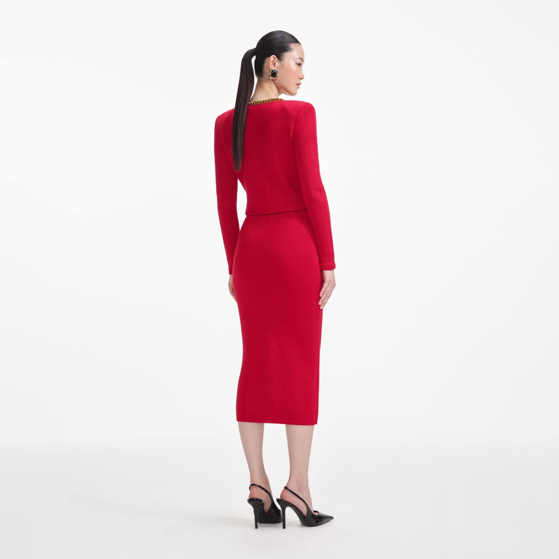 Back view of a woman wearing the Red Textured Knit Corsage Midi Skirt