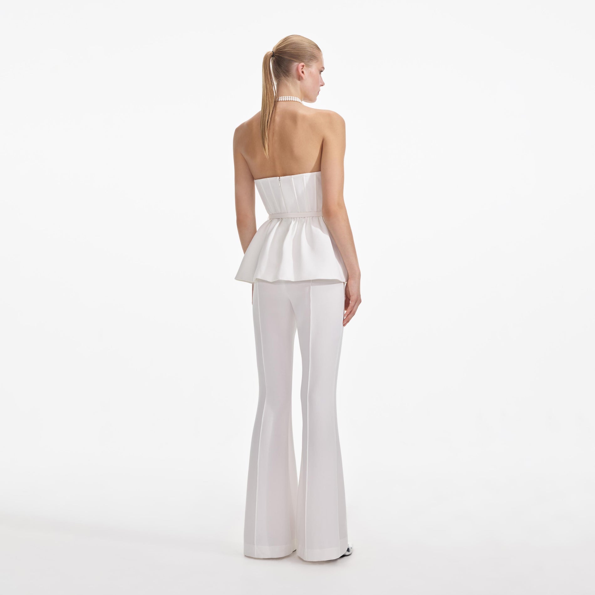 Back view of a woman wearing the White Strech Crepe Jumpsuit