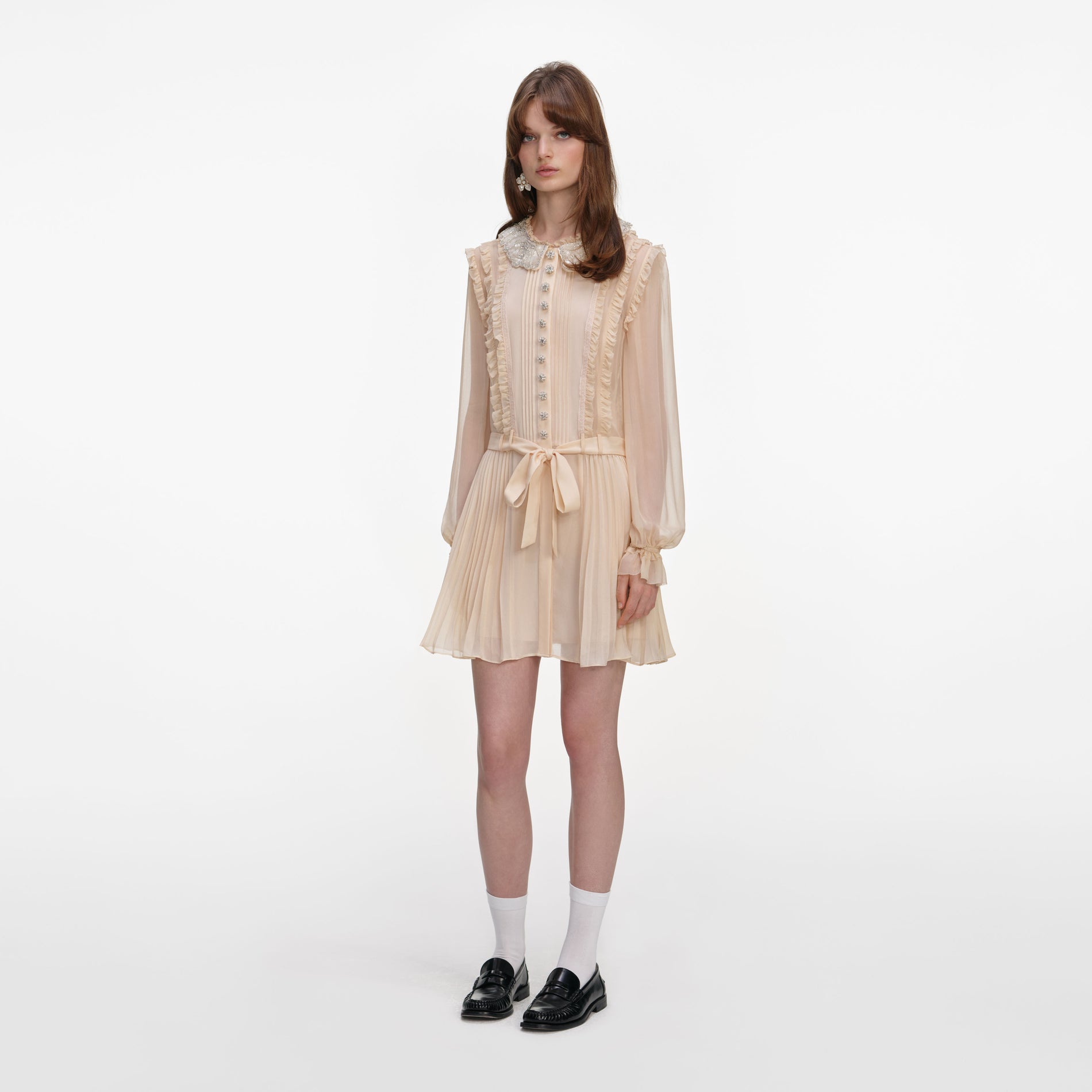 Side view of a woman wearing the Tan Pleated Georgette Mini Dress