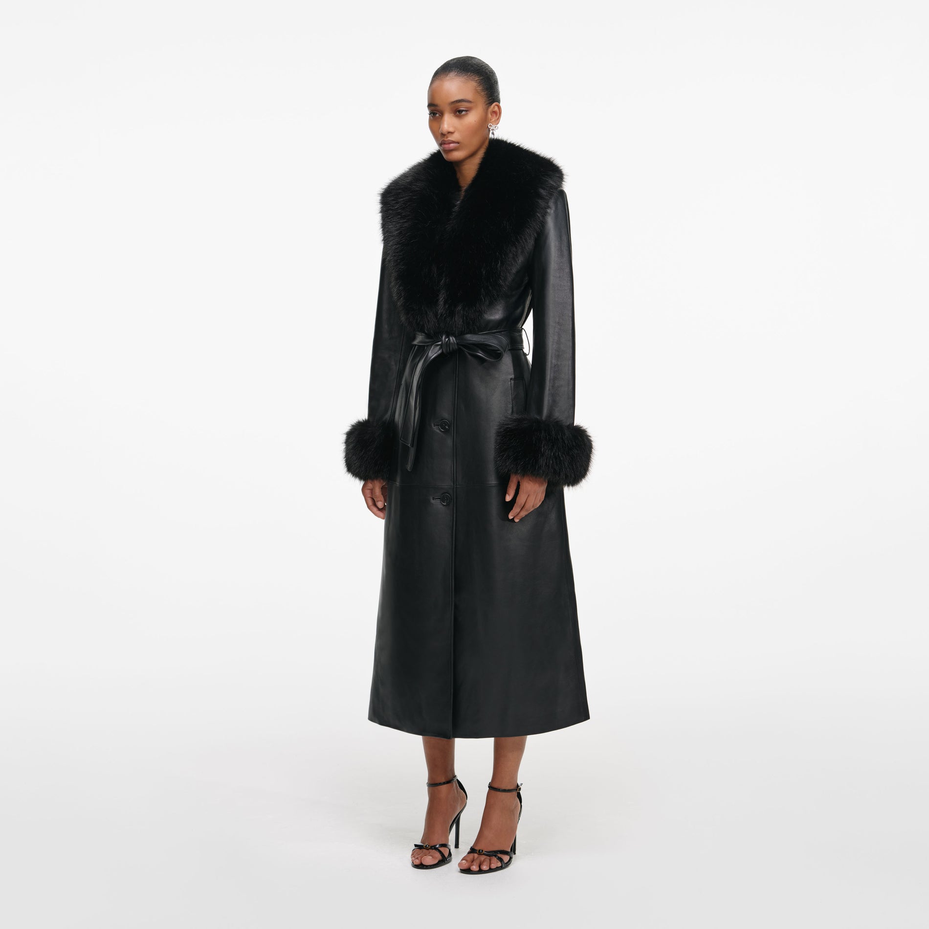 Side view of a woman wearing the Black Leather Faux Fur Collared Coat