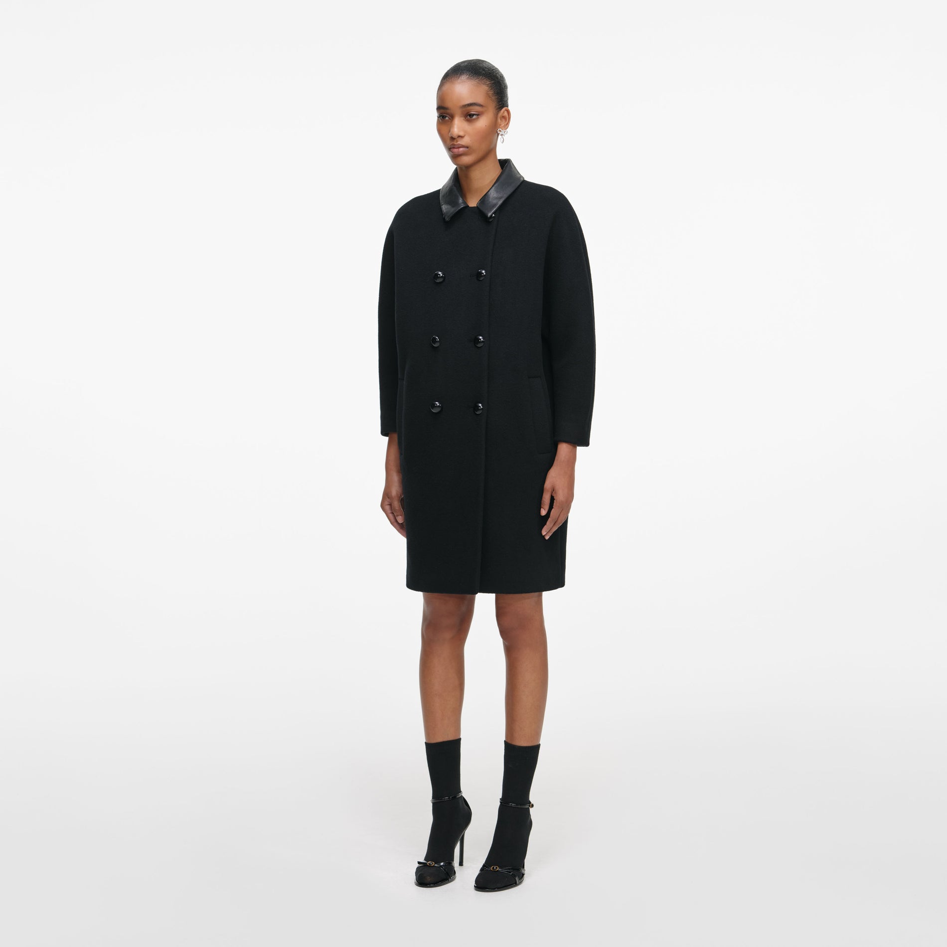 Side view of a woman wearing the Black Double Breasted Coat