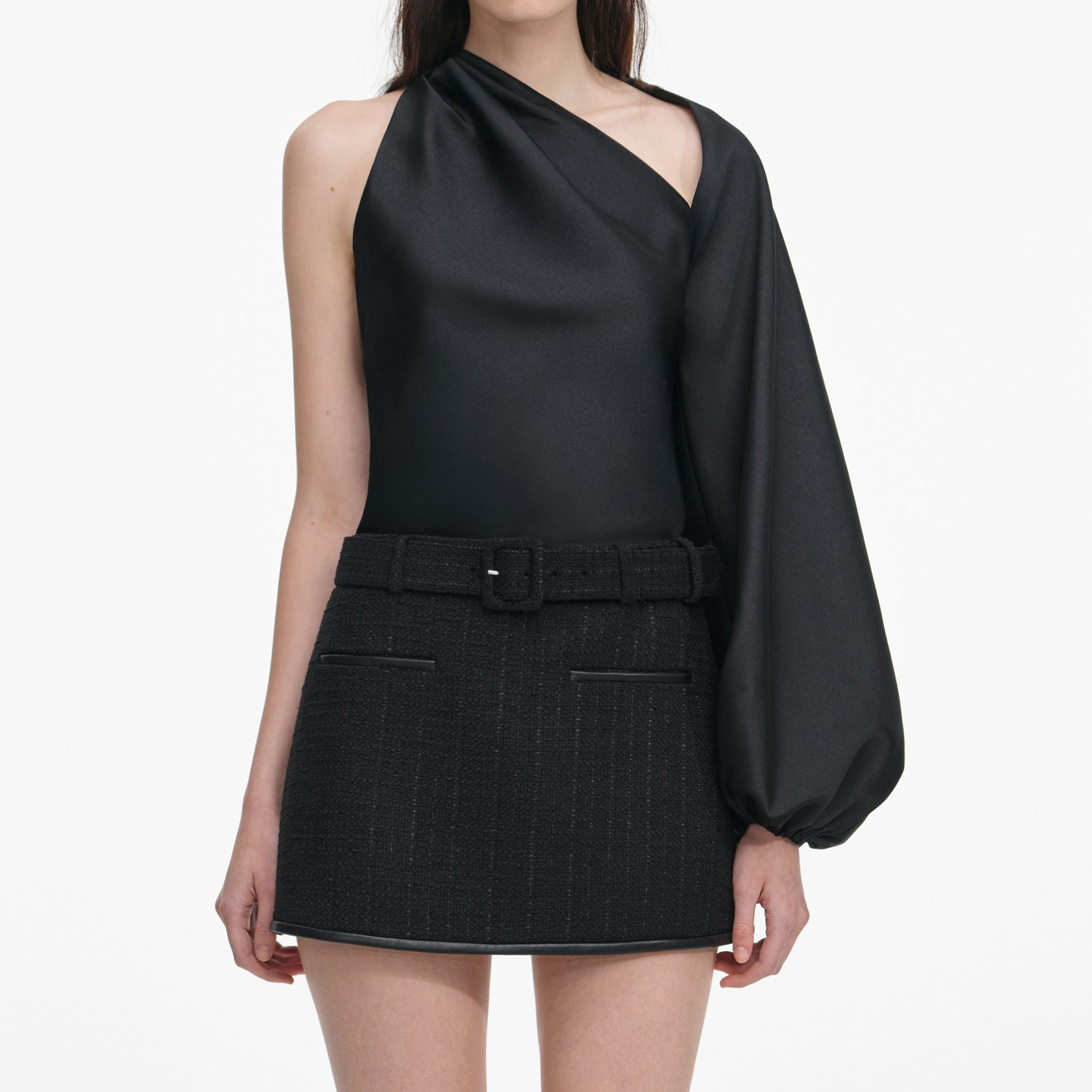 A close up of a woman wearing the Black Boucle Mini Skirt