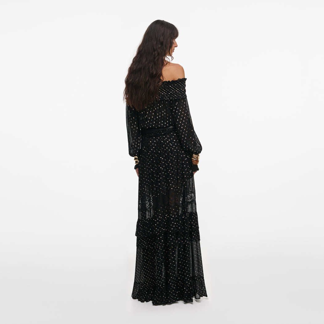 Back view of a woman wearing the Black And Gold Chiffon Lace Maxi Skirt