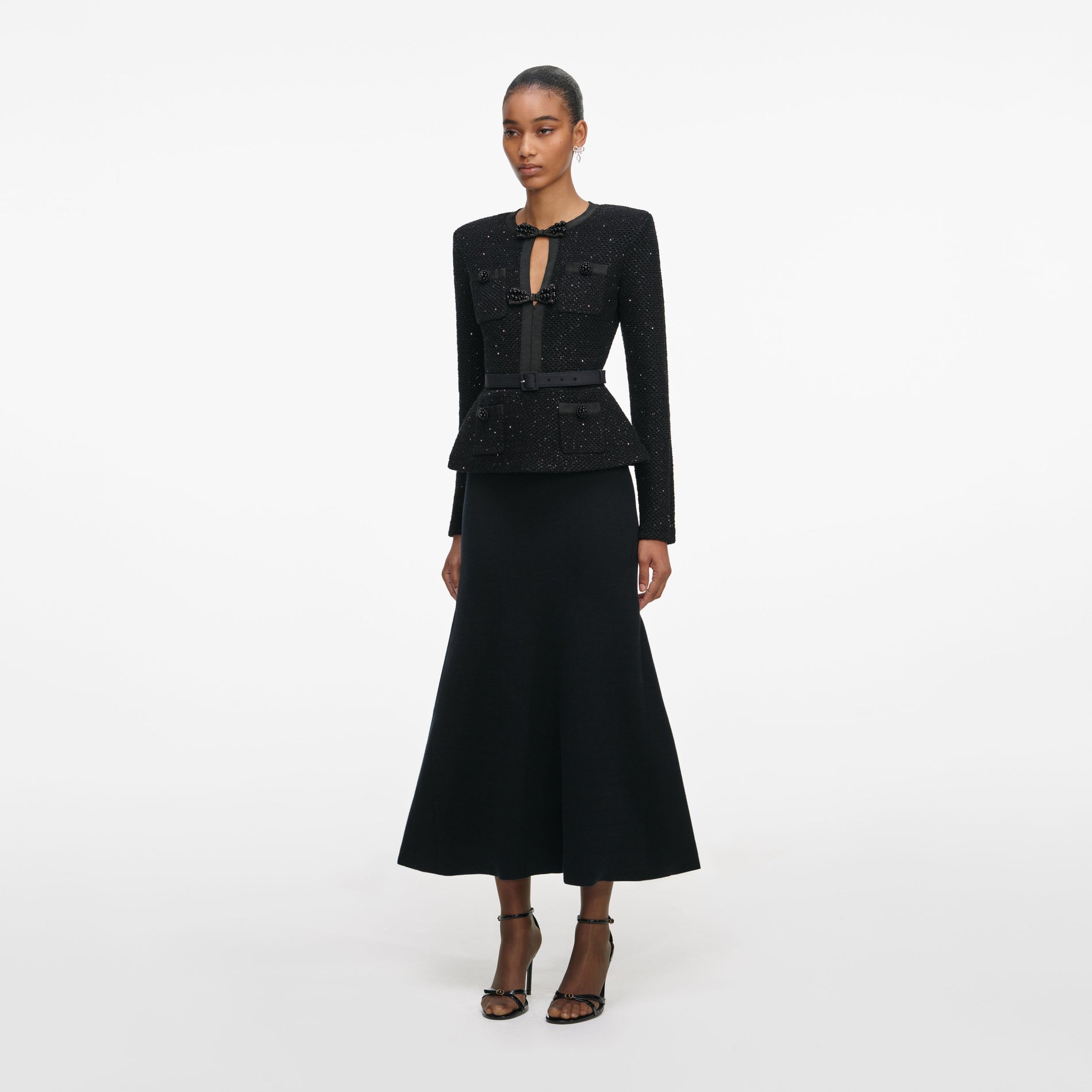 Side view of a woman wearing the Black Sequin Knit Tailored Midi Dress