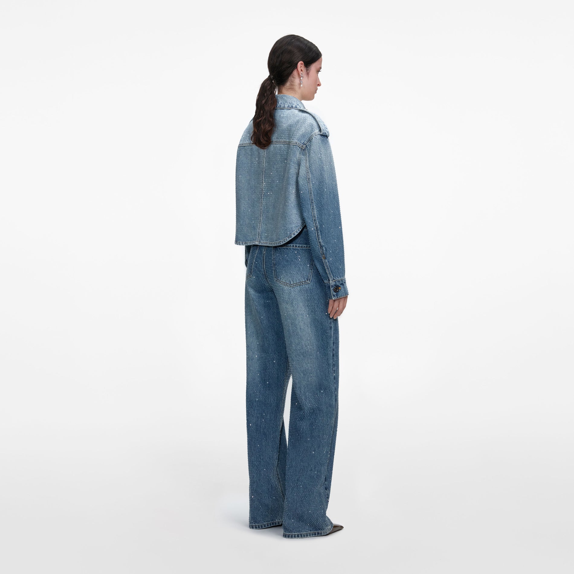 Back view of a woman wearing the Rhinestone Denim Shirt