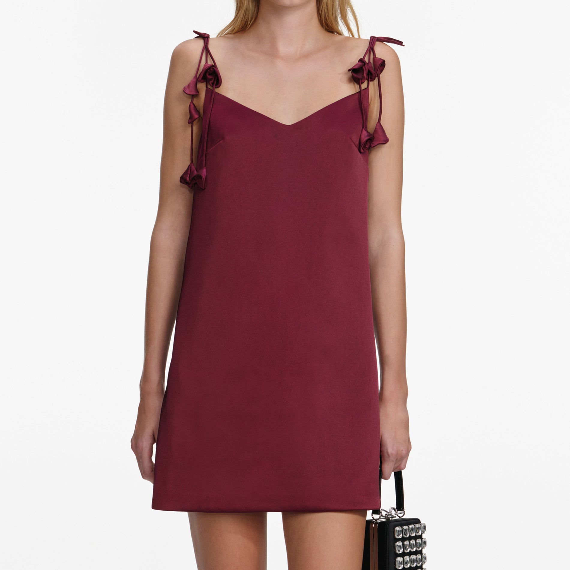 A close up of a woman wearing the Burgundy Satin Flower Mini Dress