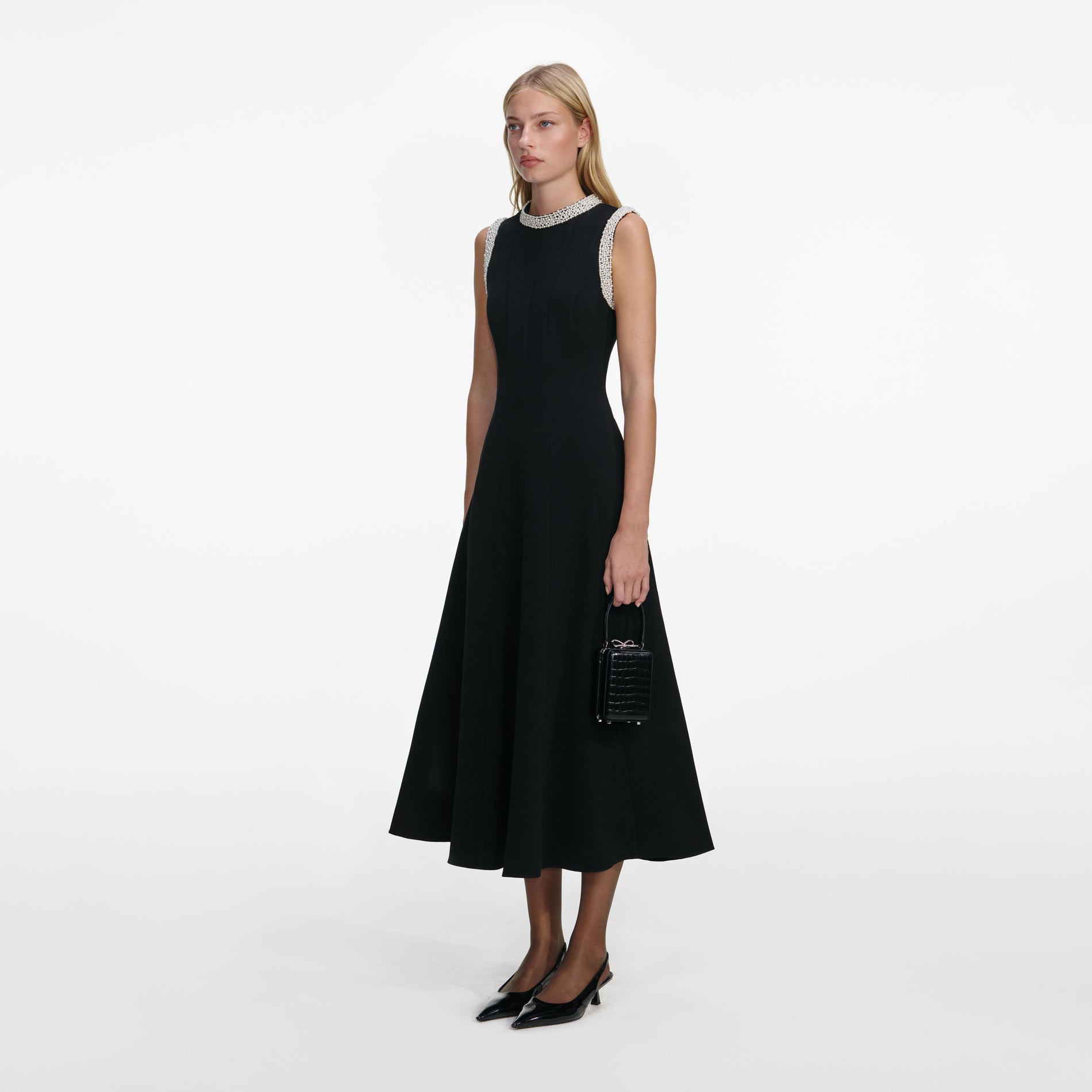 Side view of a woman wearing the Black Crepe Pearl Trim Midi Dress