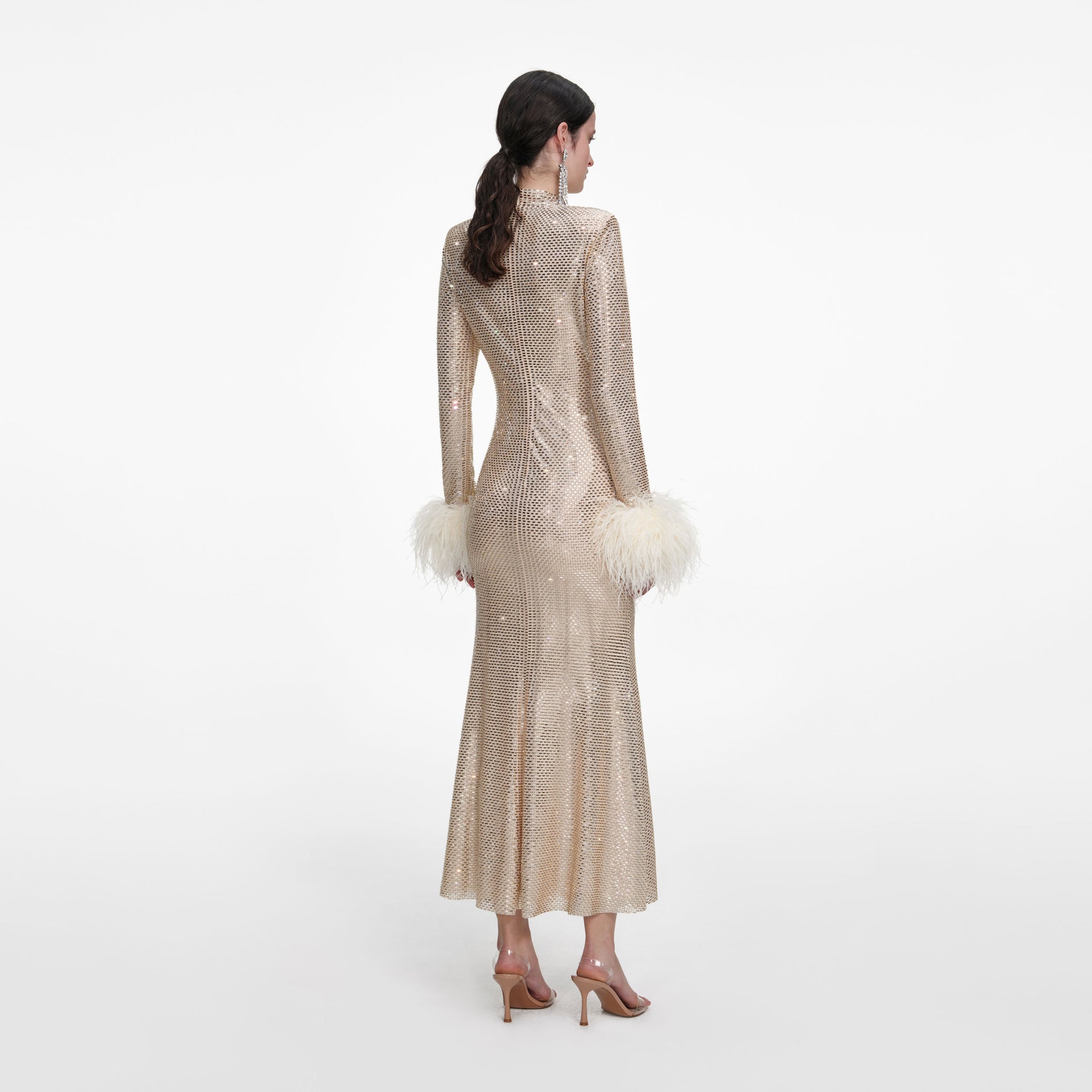 Back view of a woman wearing the Champagne Rhinestone Feather Midi Dress