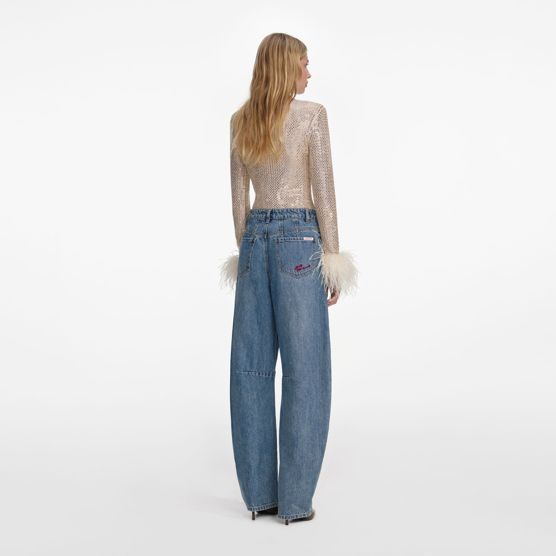 Back view of a woman wearing the Champagne Rhinestone Feather Top