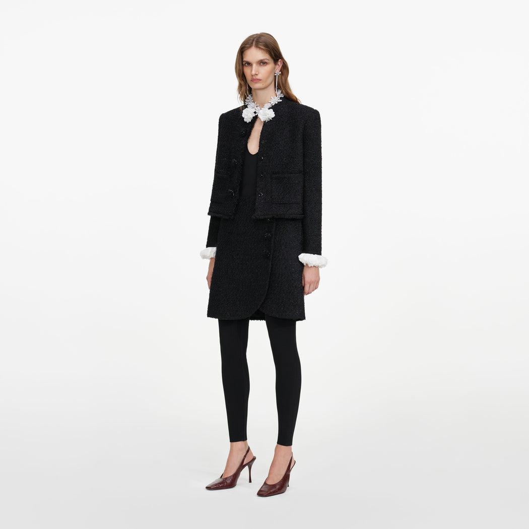 Side view of a woman wearing the Black Boucle Flower Jacket