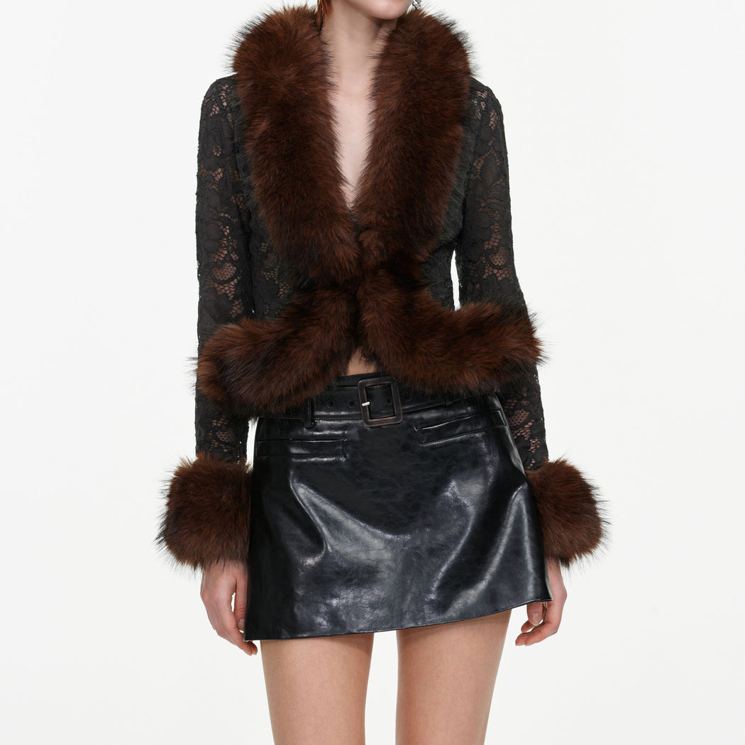 A close up of a woman wearing the Black Faux Leather Mini Skirt