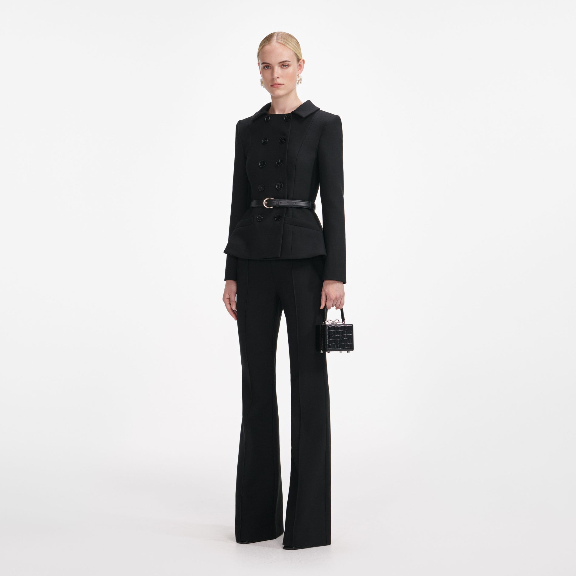 Side view of a woman wearing the Black Wool Double Breasted Jumpsuit