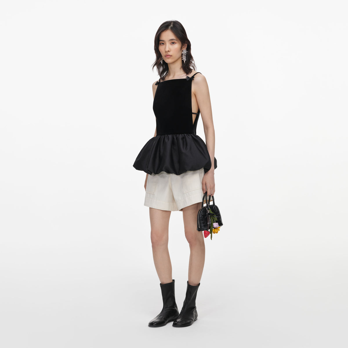 Side view of a woman wearing the Black Velvet Bubble Hem Top