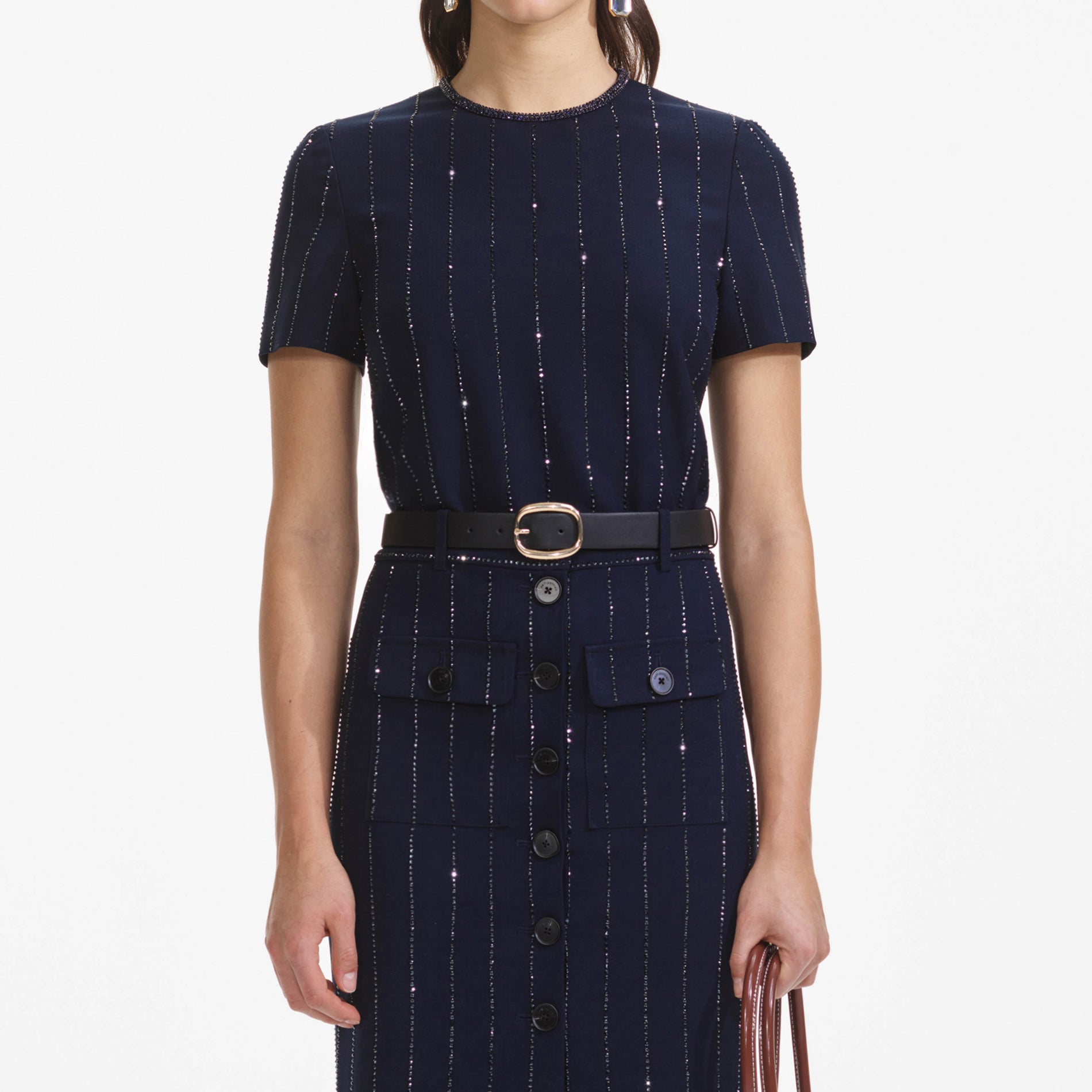 A close up of a woman wearing the Navy Rhinestone Pinstripe Midi Skirt