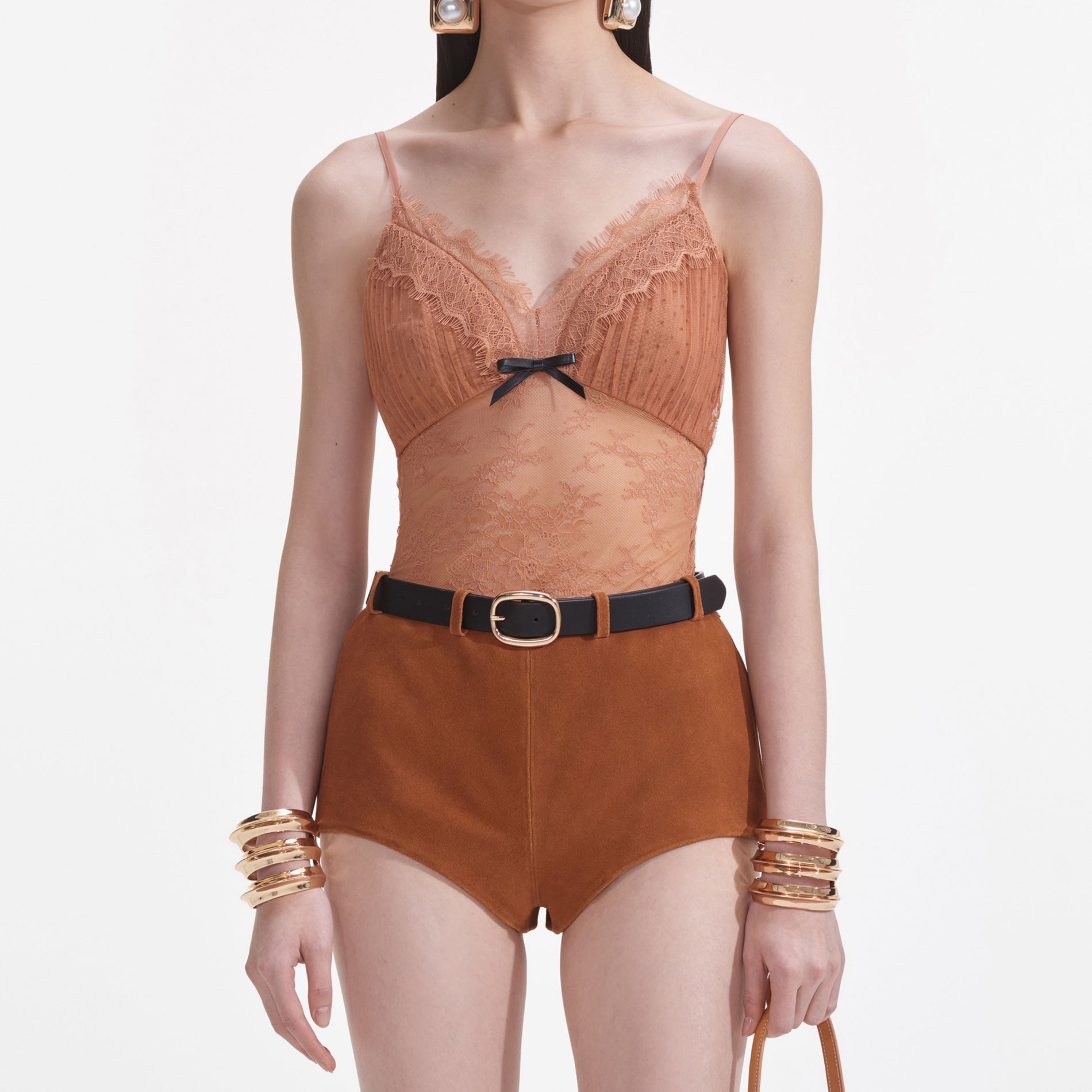 A close up of a woman wearing the Tan Dot Mesh Bodysuit