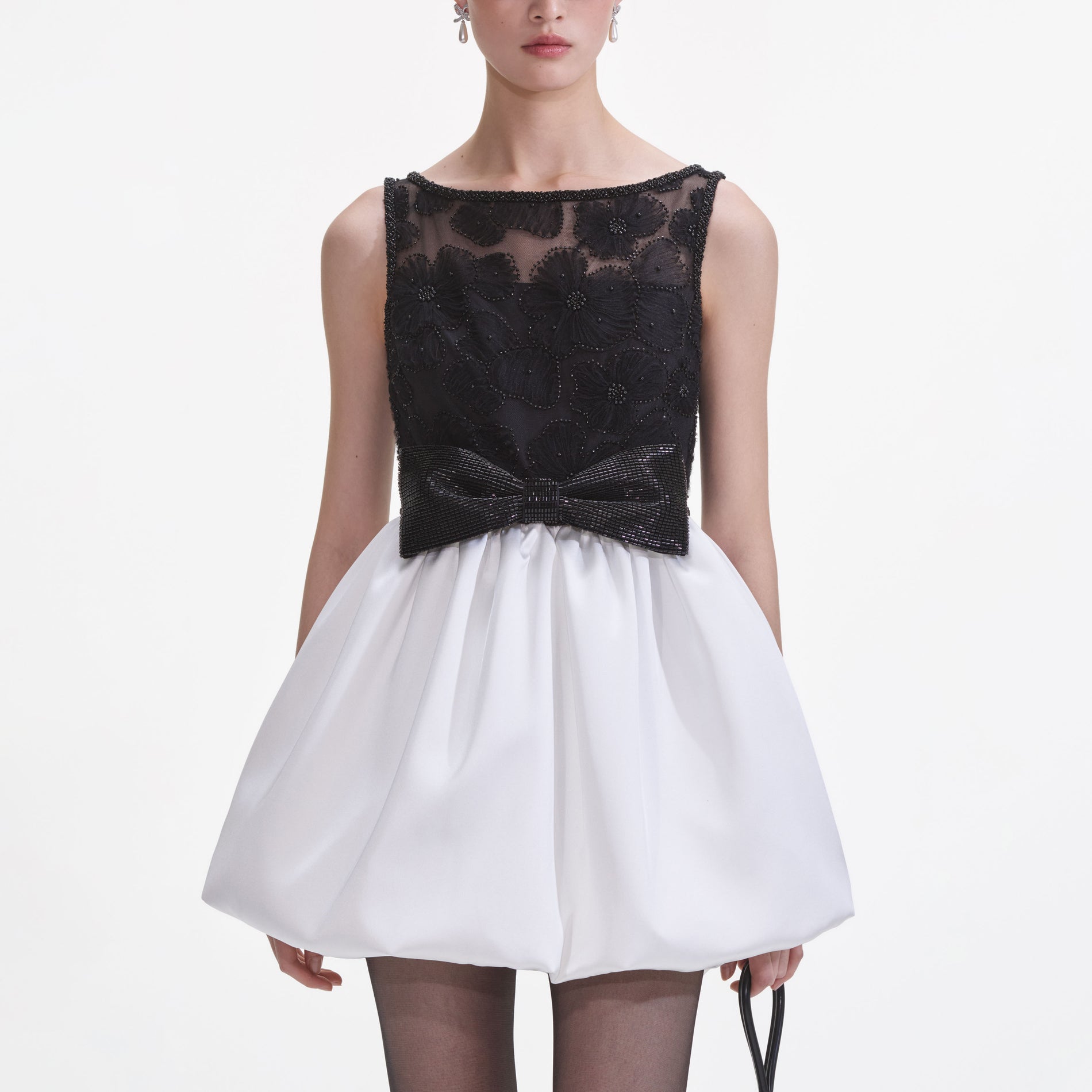 A close up of a woman wearing the Black And White Tulle Mini Dress