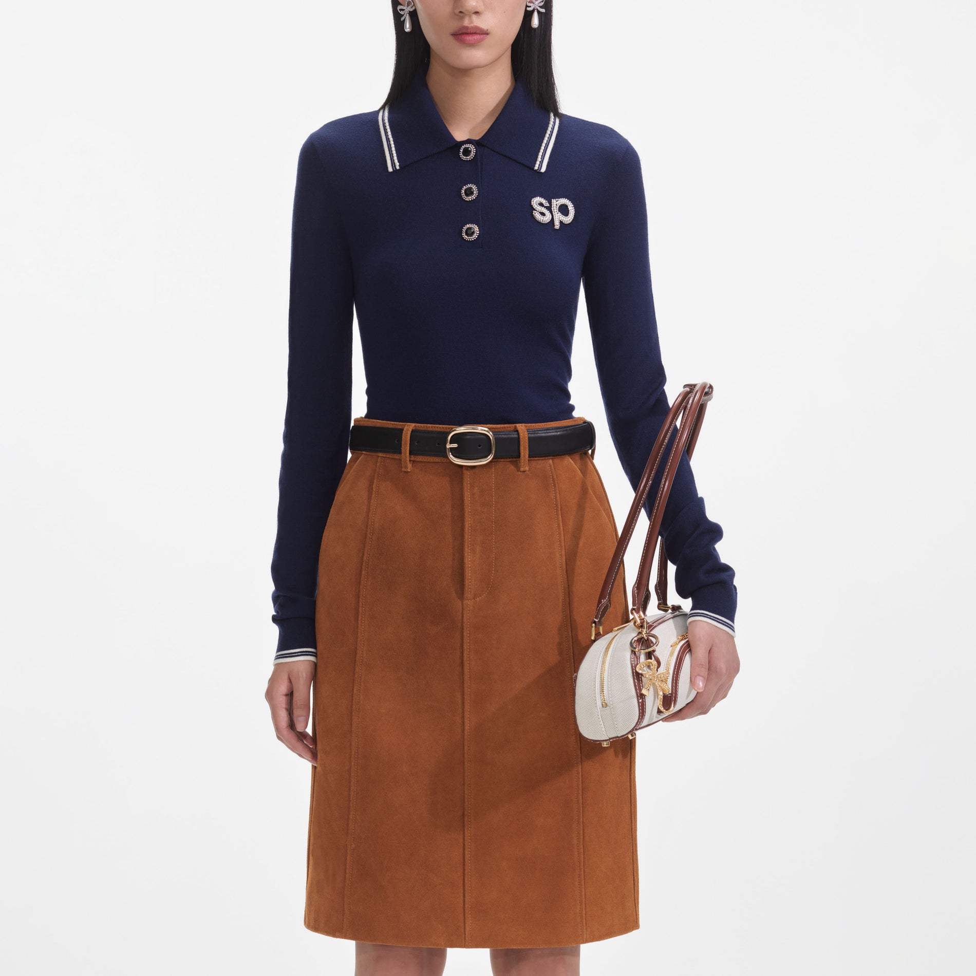 A close up of a woman wearing the Navy Knit Long Sleeve SP Polo Top