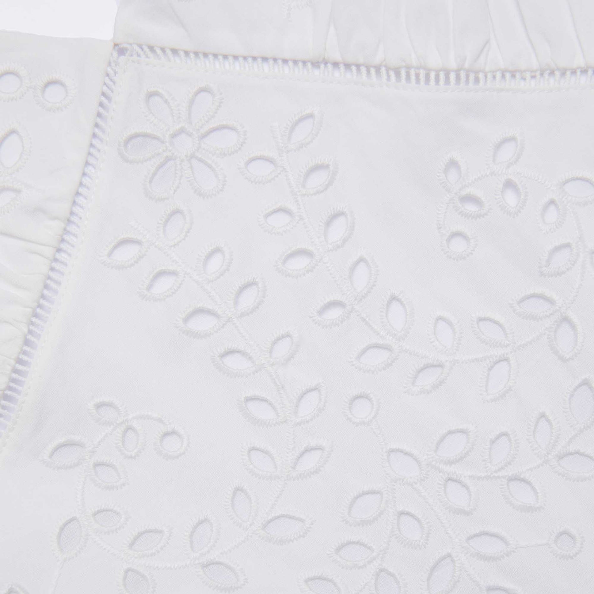 Side view of a woman wearing the White Cotton Embroidered Midi Dress