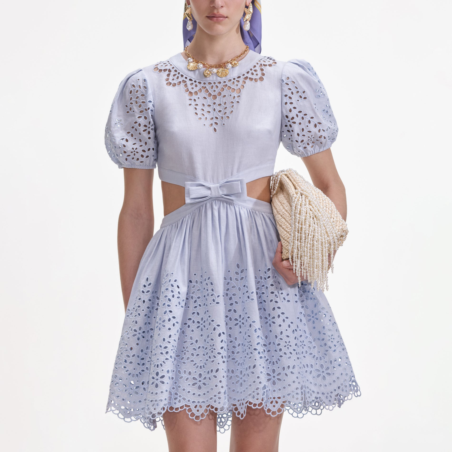 A close up of a woman wearing the Blue Embroidered Linen Mini Dress