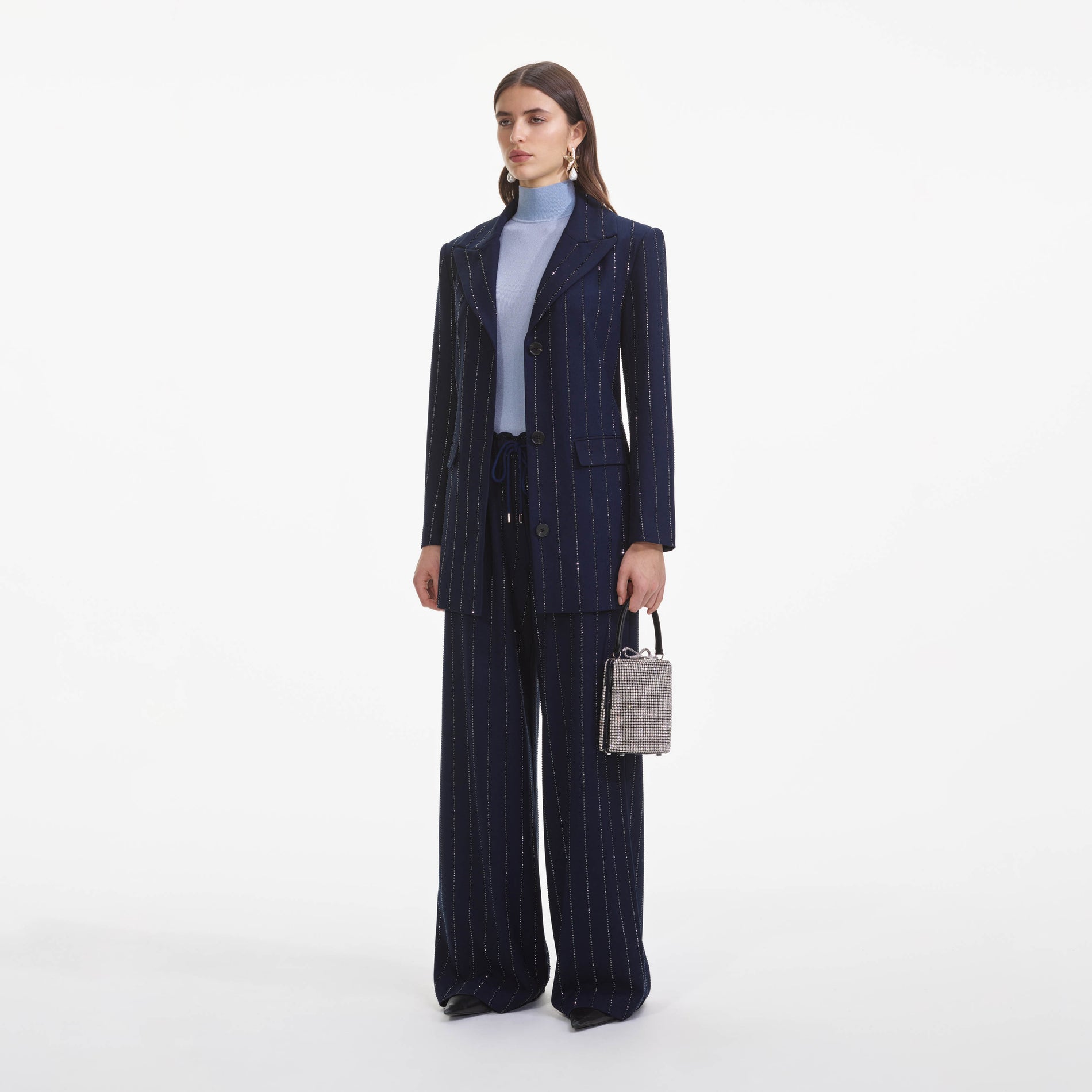 Side view of a woman wearing the Navy Rhinestone Pinstripe Trousers