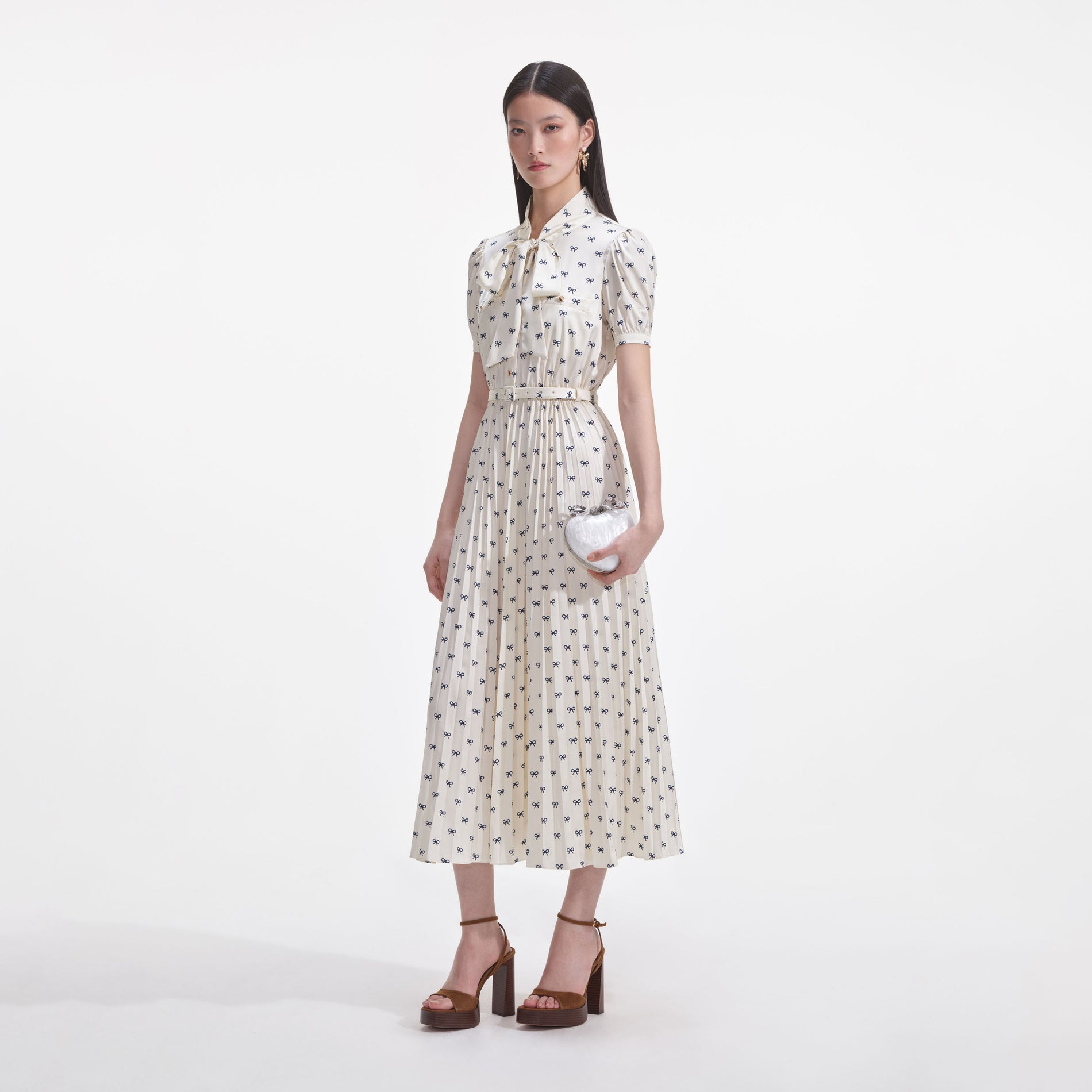 Side view of a woman wearing the Cream Satin Bow Print Midi Dress