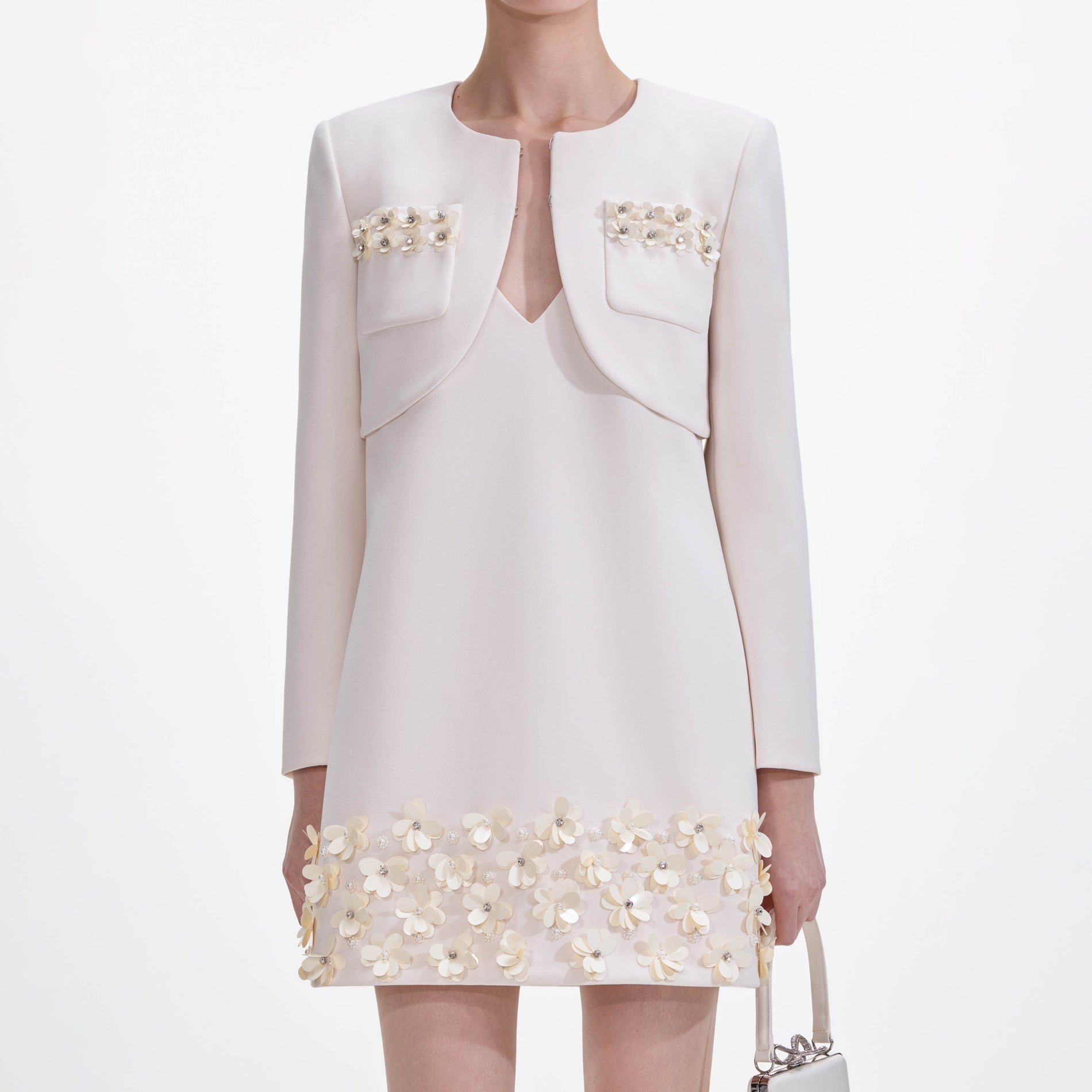 A close up of a woman wearing the Cream Crepe 3D Sequin Jacket