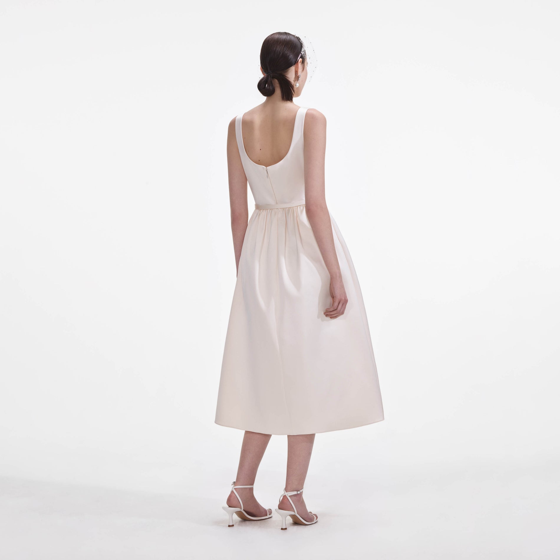 Back view of a woman wearing the Cream Satin Flower Midi Dress