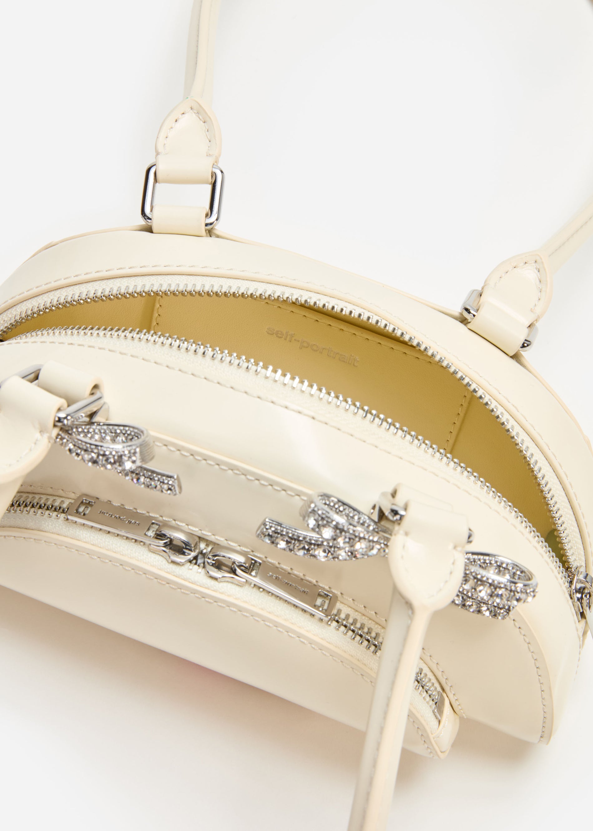 A photo of the Cream Leather Curved Mini Shoulder Bag