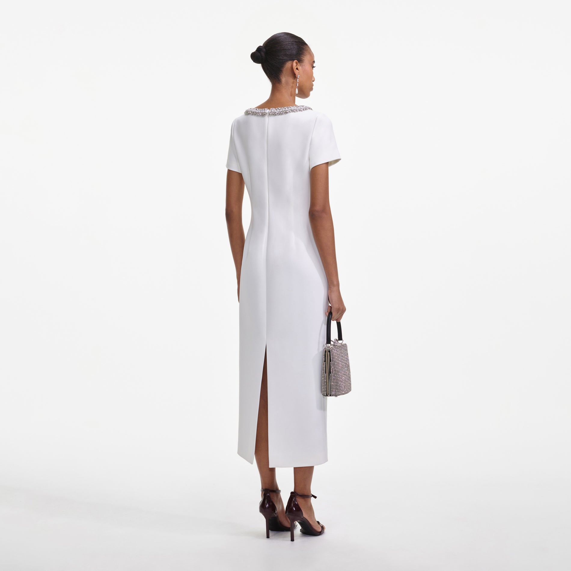 Back view of a woman wearing the White Crepe Bow Midi Dress