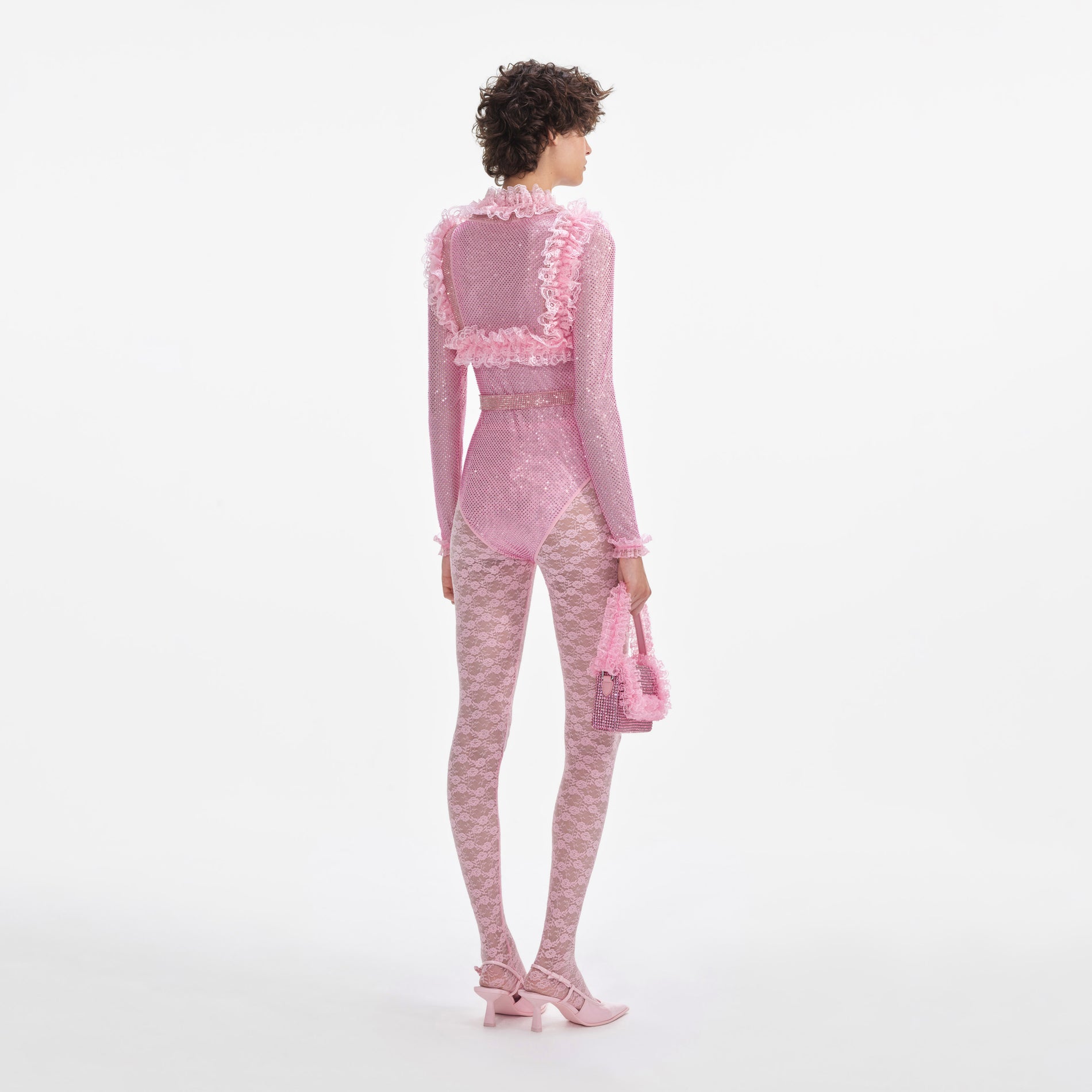 Back view of a woman wearing the Pink Rhinestone Mesh Ruffle Bodysuit