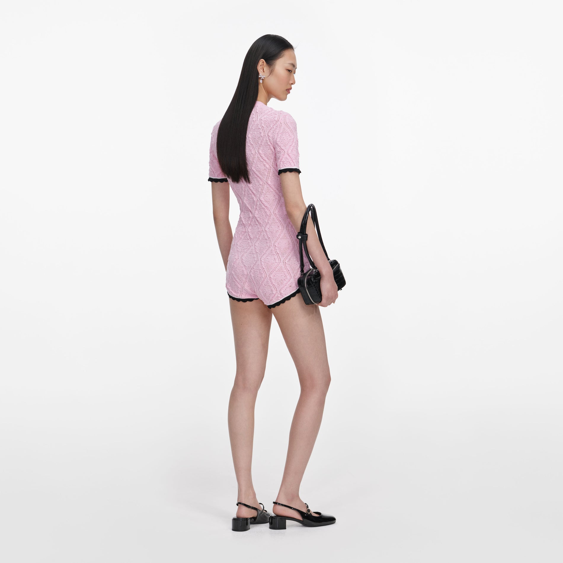 Back view of a woman wearing the Pink Pointelle Knit Playsuit