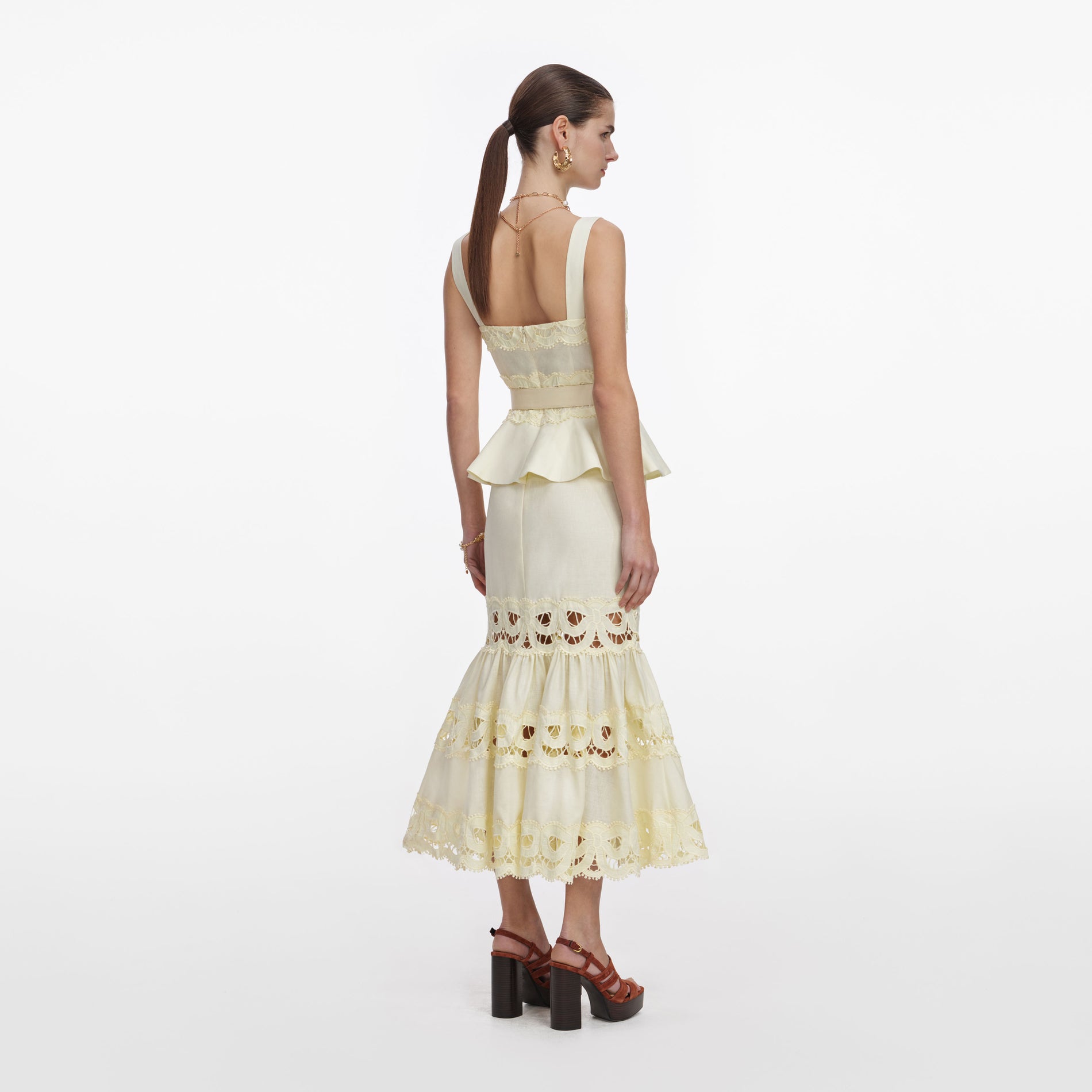 Back view of a woman wearing the Yellow Linen Peplum Midi Dress