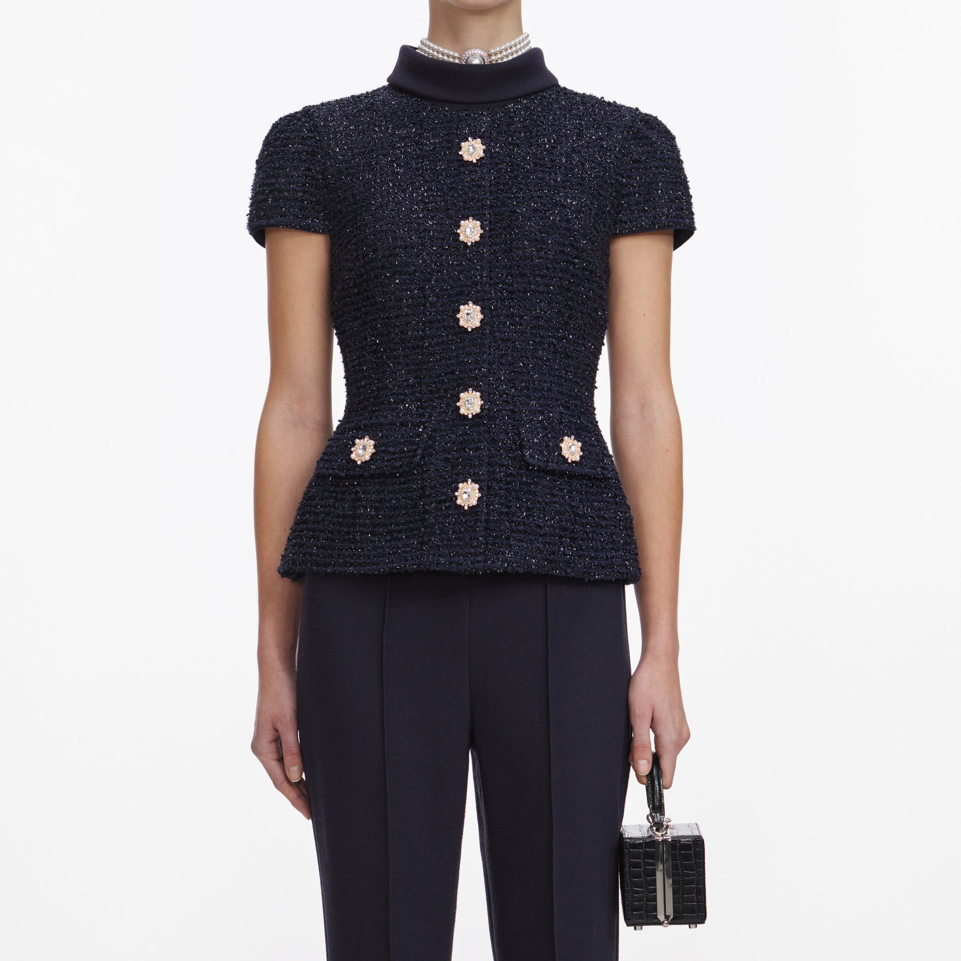 A close up of a woman wearing the Navy Metallic Boucle Jumpsuit
