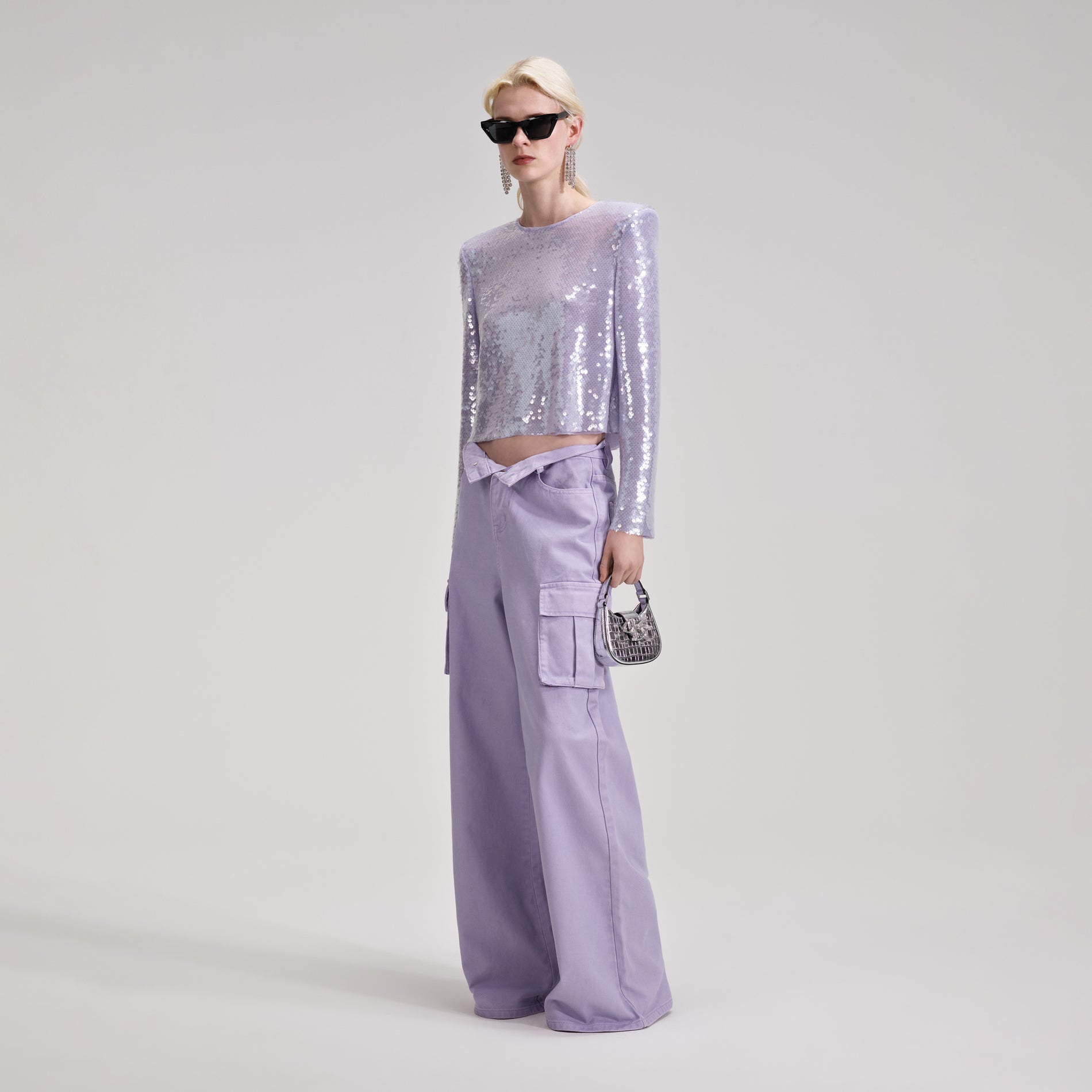 A woman wearing the Lilac Sequin Top